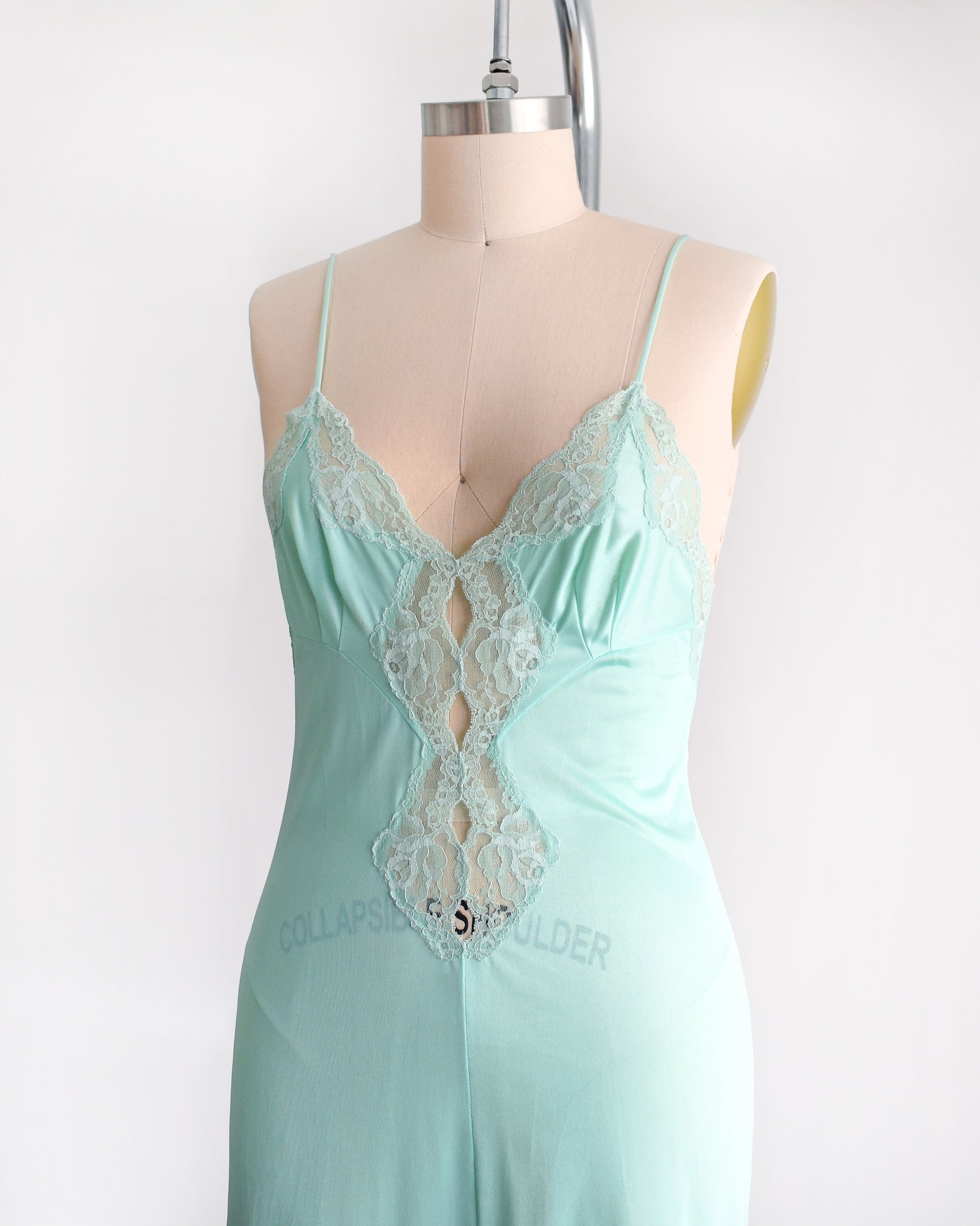 Side front view of a vintage 1970s mint green nightgown with lace trim