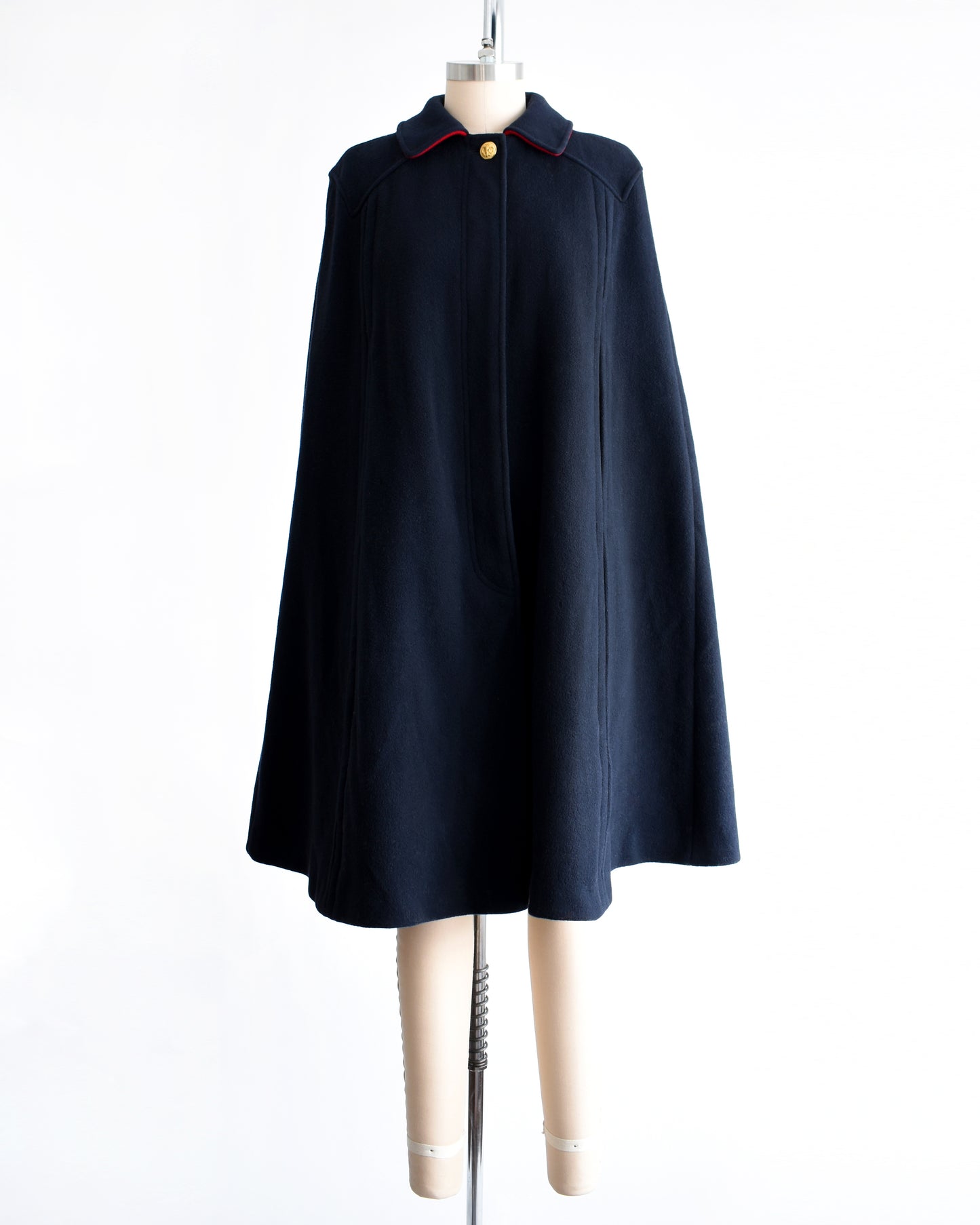 a vintage 1970s navy blue cape on a mannequin against a white background