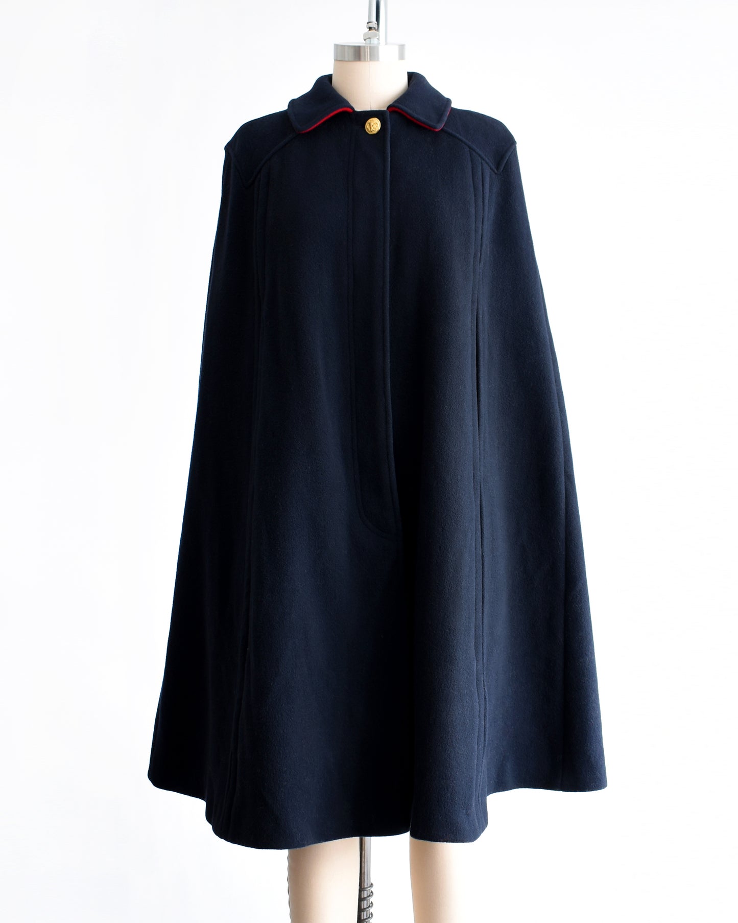 a vintage 1970s navy blue cape on a mannequin against a white background