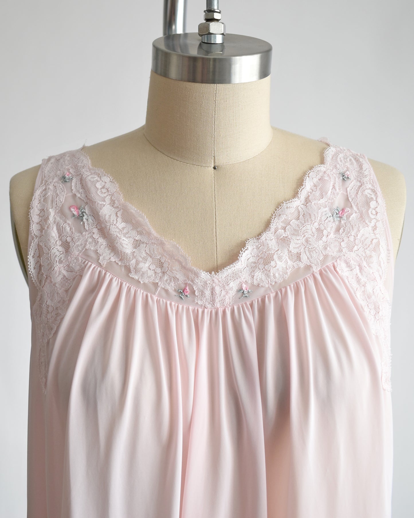 Close up of the front of the neckline that features floral lace and small embroidered flowers