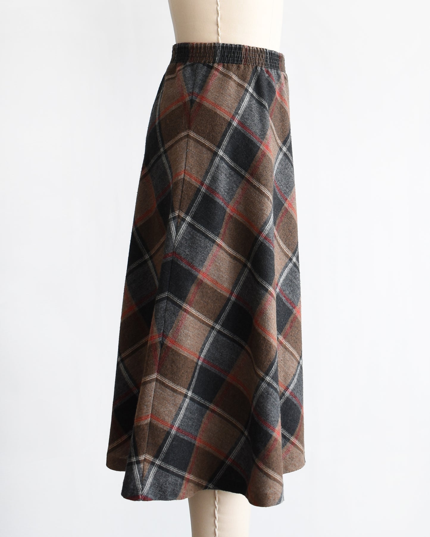 side view of a vintage 1980s plaid skirt on a mannequin against a white background
