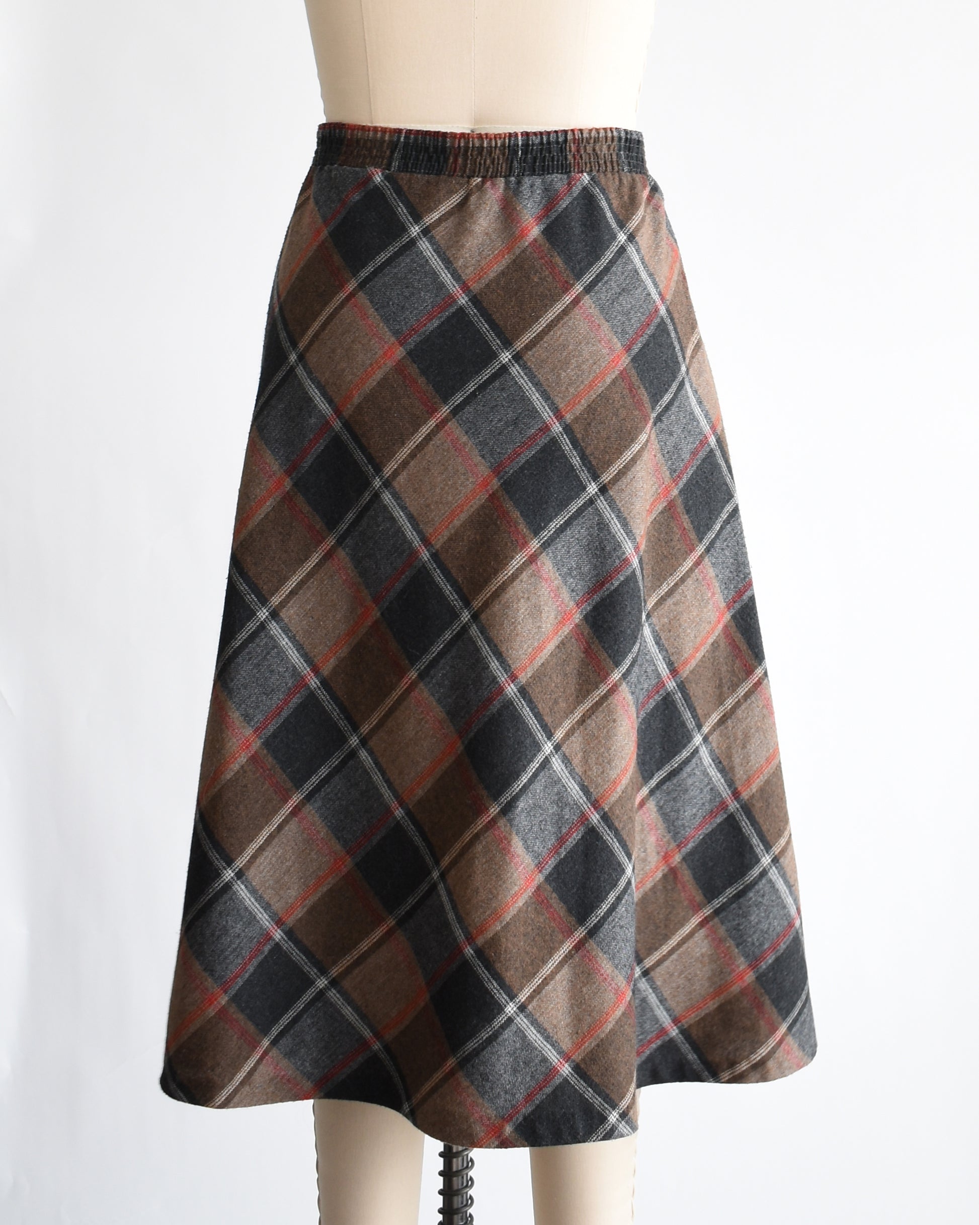 back view of a vintage 1980s plaid skirt on a mannequin against a white background