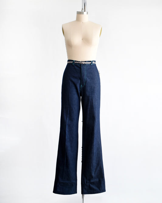 a pair of vintage 1970s dark blue wide leg jeans on a mannequin on a white background