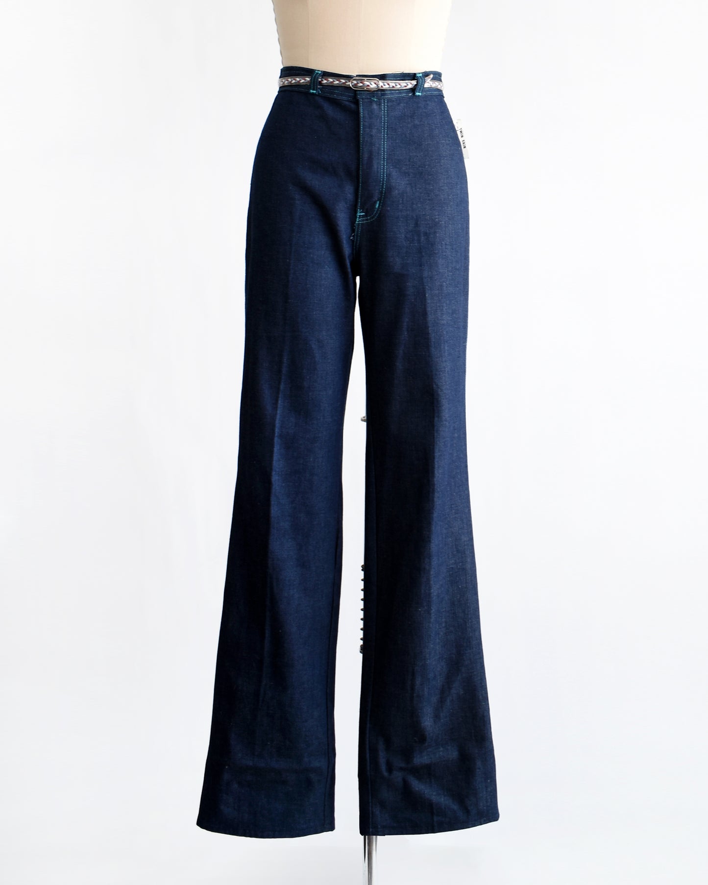 a pair of vintage 1970s dark blue wide leg jeans on a mannequin on a white background