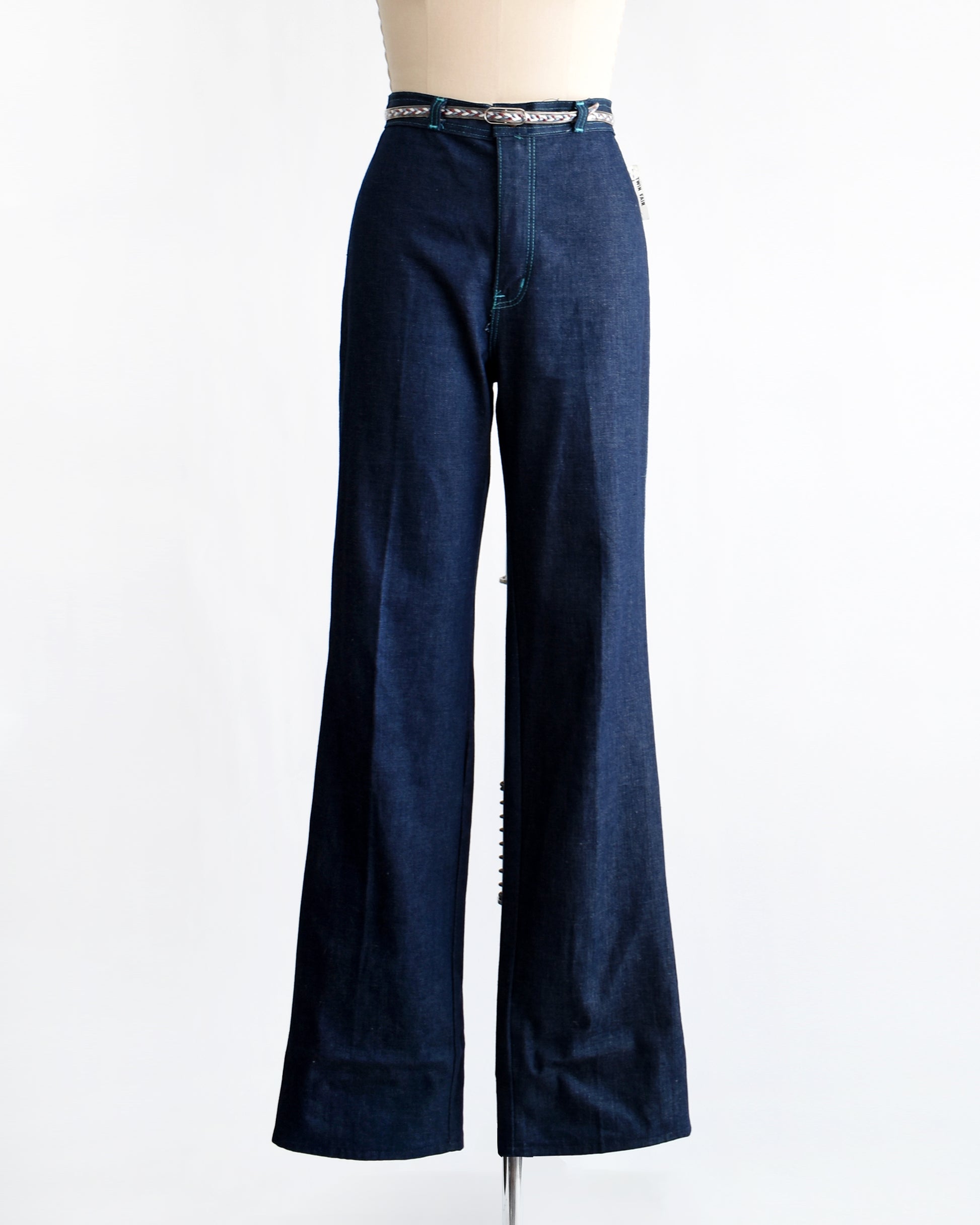 a pair of vintage 1970s dark blue wide leg jeans on a mannequin on a white background