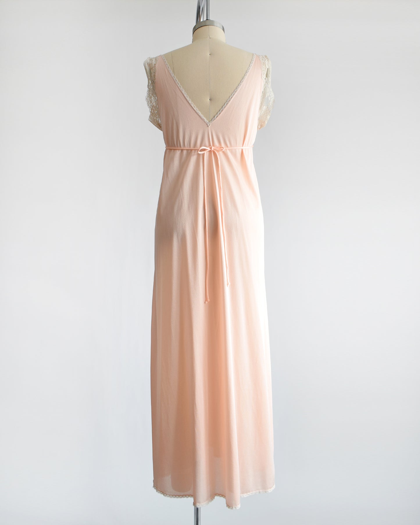 Back view of a vintage 1970s peach nightgown with lace trim