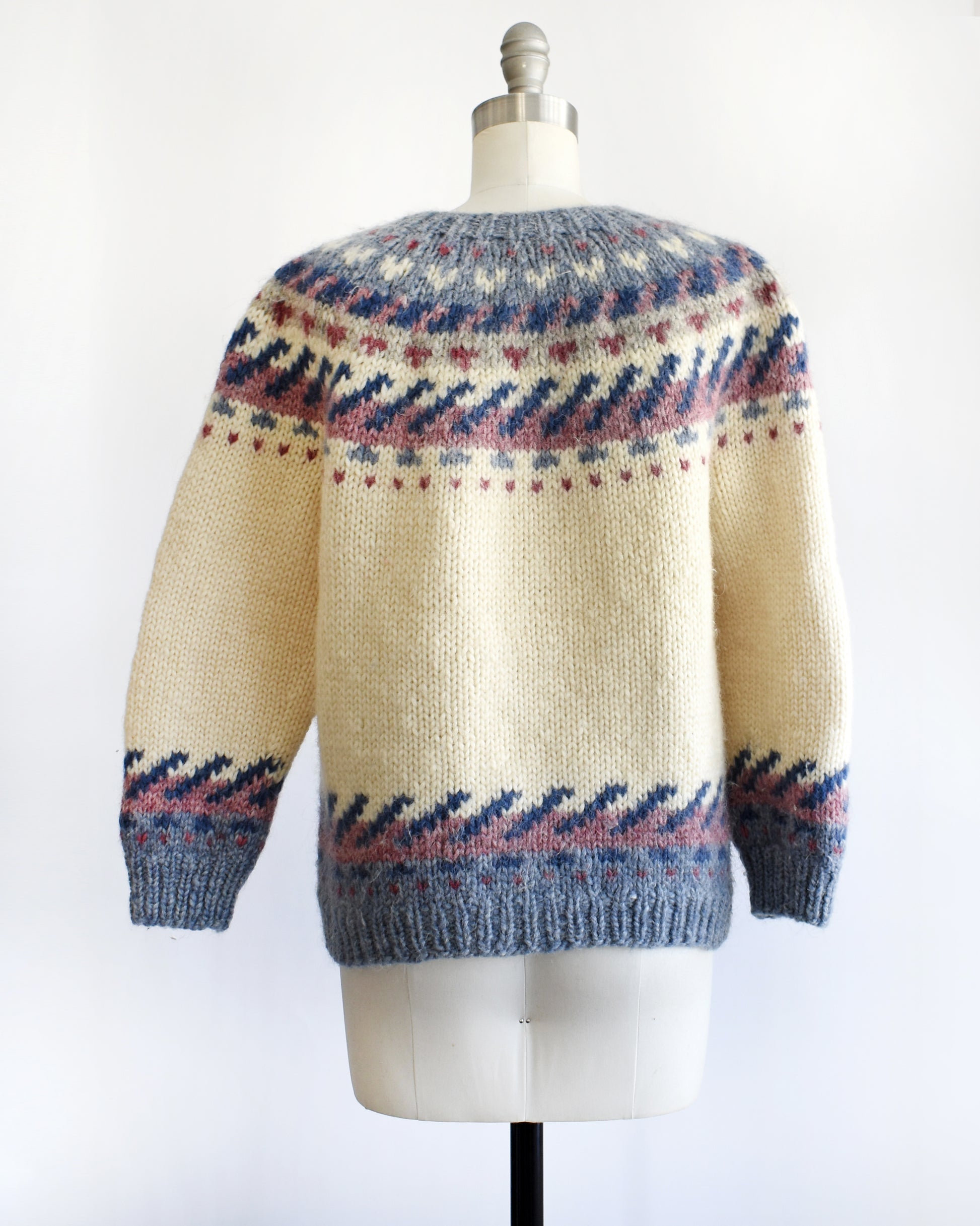 back view of a vintage 1970s Icelandic knitted sweater with a pattern on a mannequin against a white background