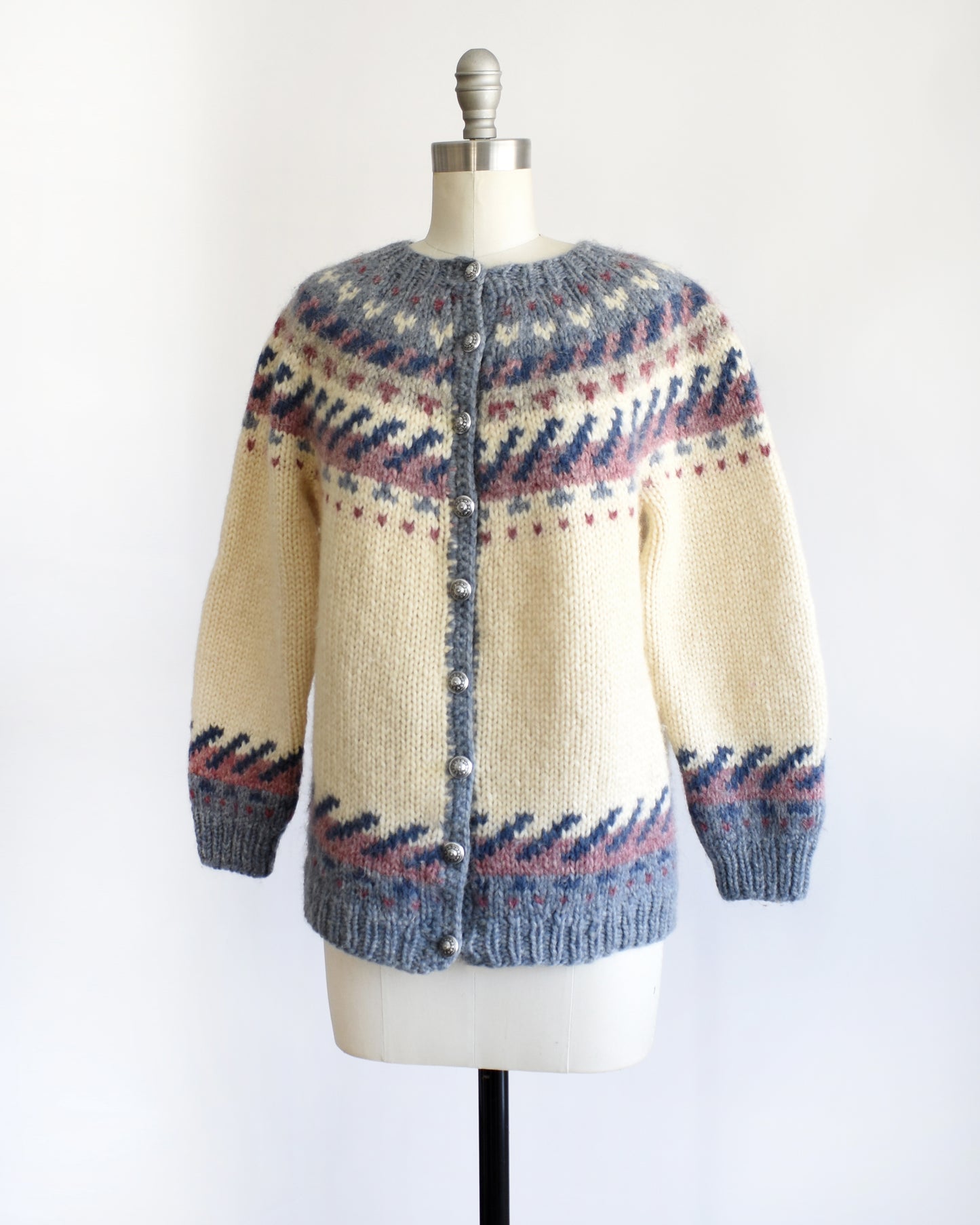 side front view of a vintage 1970s Icelandic knitted sweater with a pattern on a mannequin against a white background