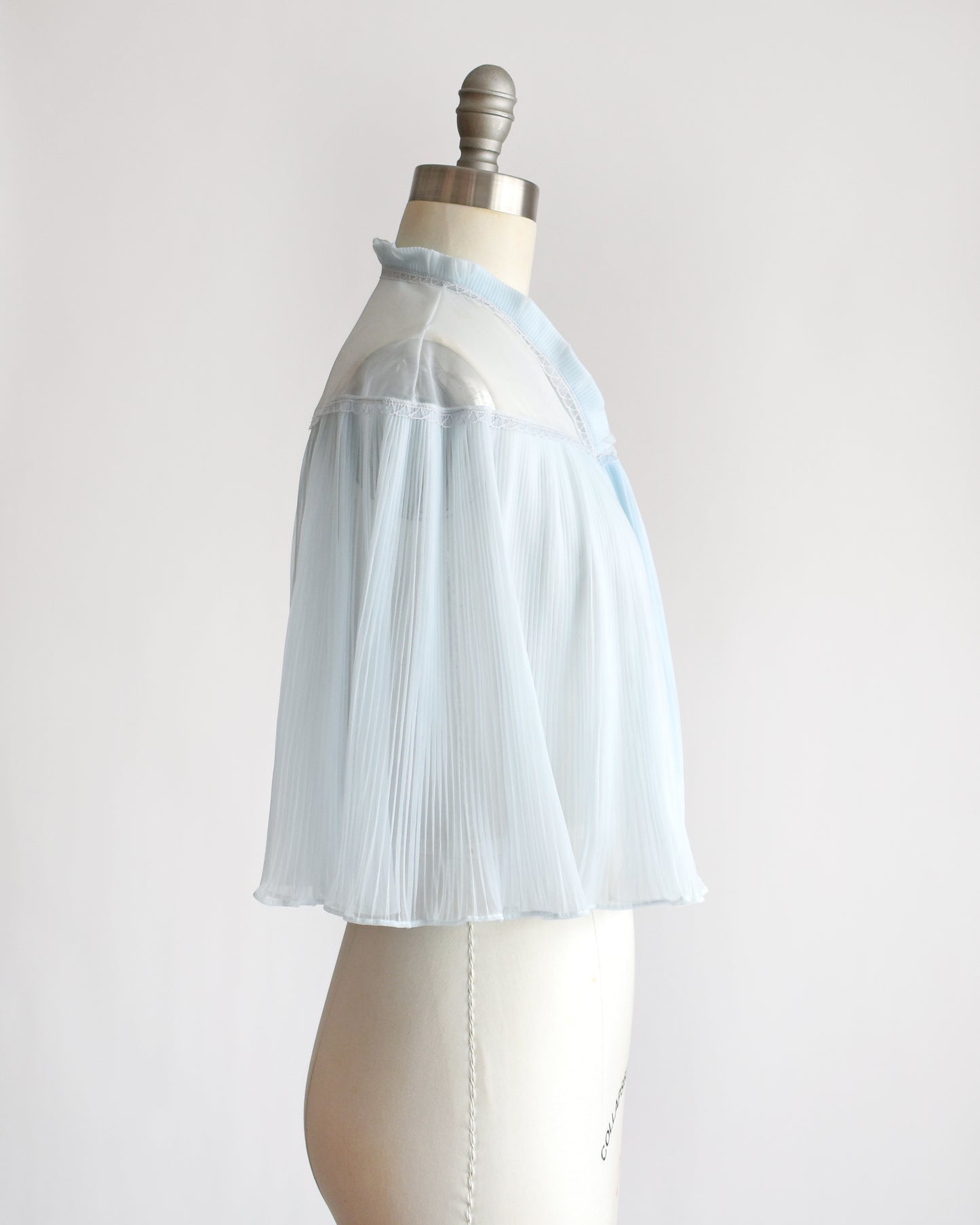 side view of a vintage 1960s light blue pleated bed jacket