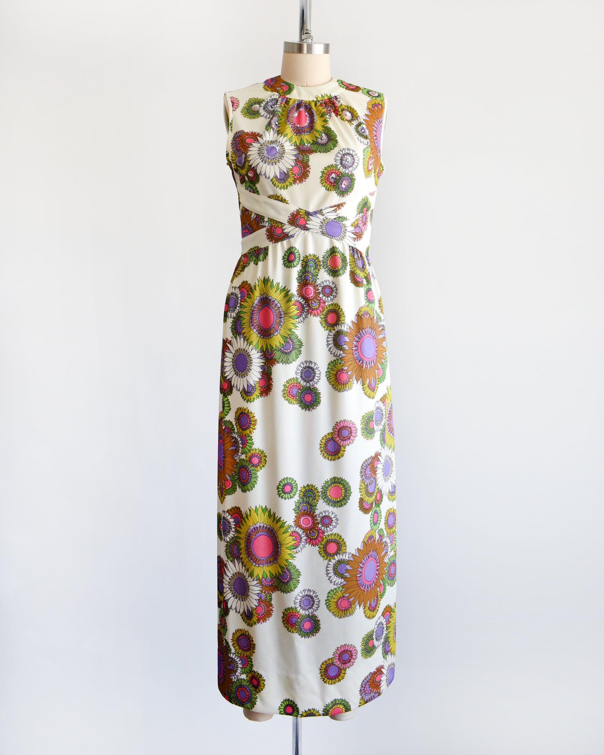 a vintage 1970s colorful floral dress on a mannequin against a white background