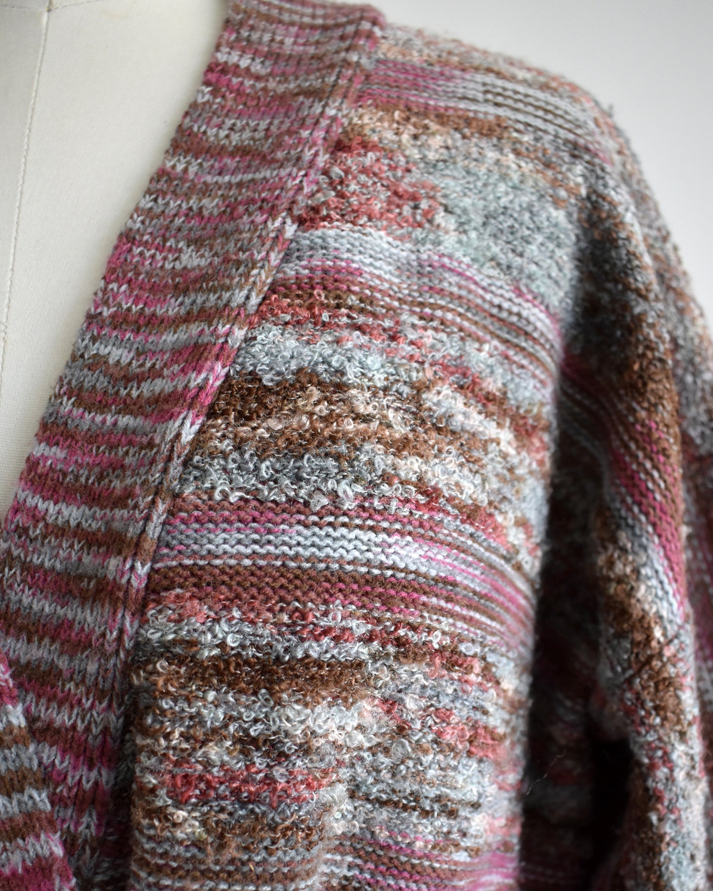 close up of the knit on a vintage 1970s space dye wrap cardigan on a dress form against a white background