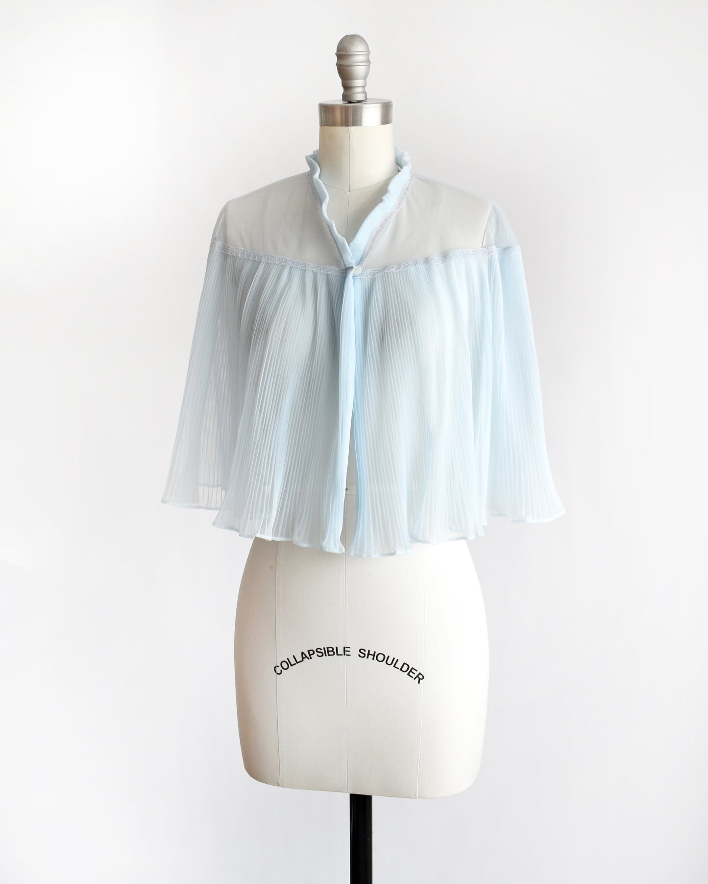 side front view of a vintage 1960s light blue pleated bed jacket