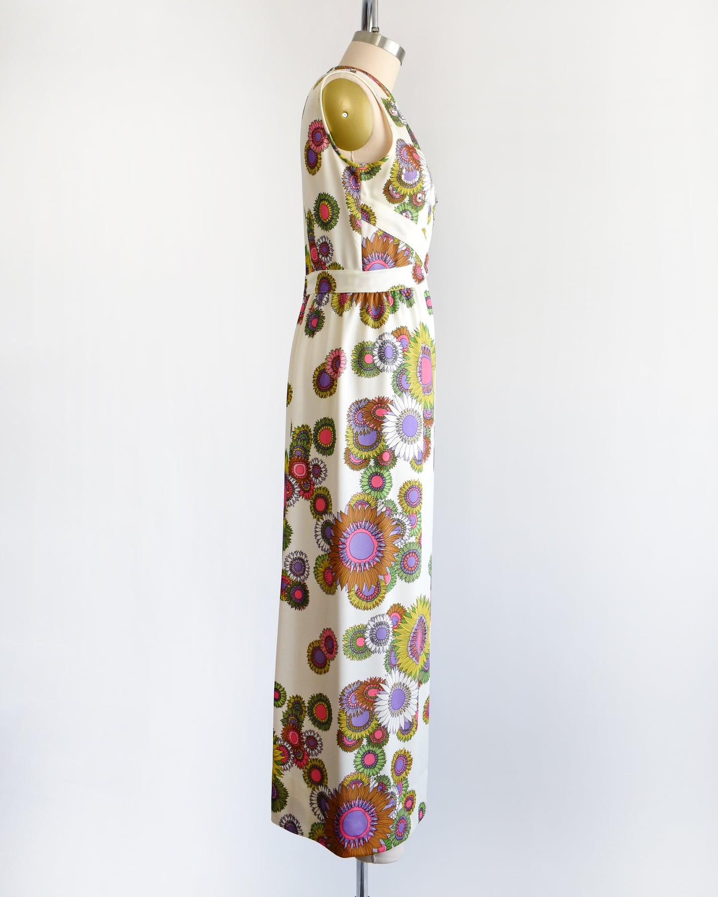 side view of a vintage 1970s colorful floral dress on a mannequin against a white background