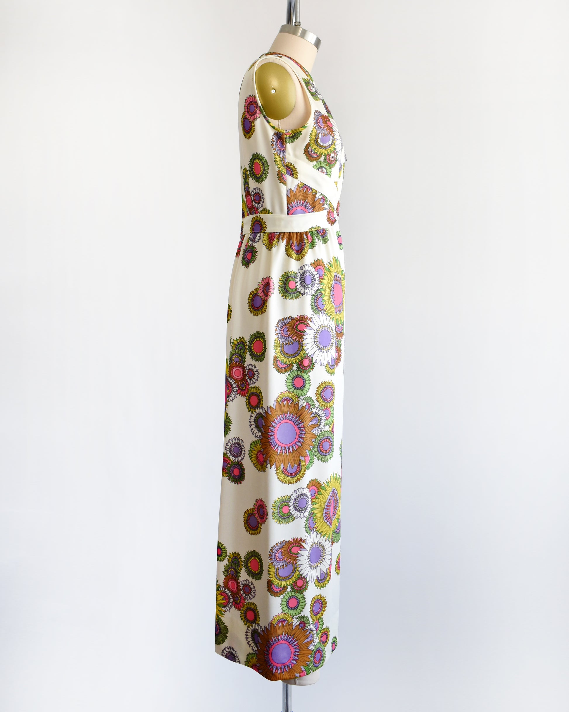 side view of a vintage 1970s colorful floral dress on a mannequin against a white background
