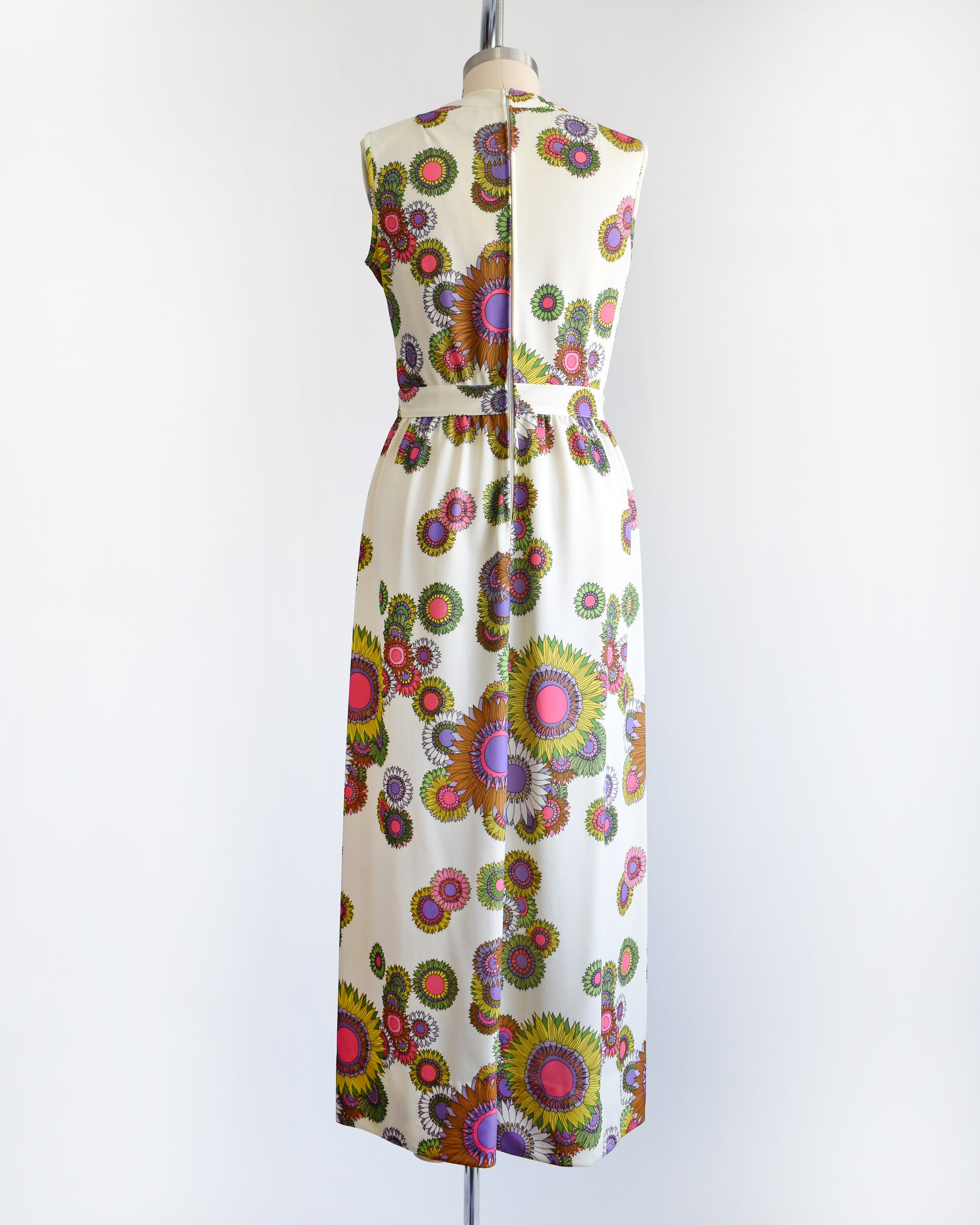 back view of a vintage 1970s colorful floral dress on a mannequin against a white background