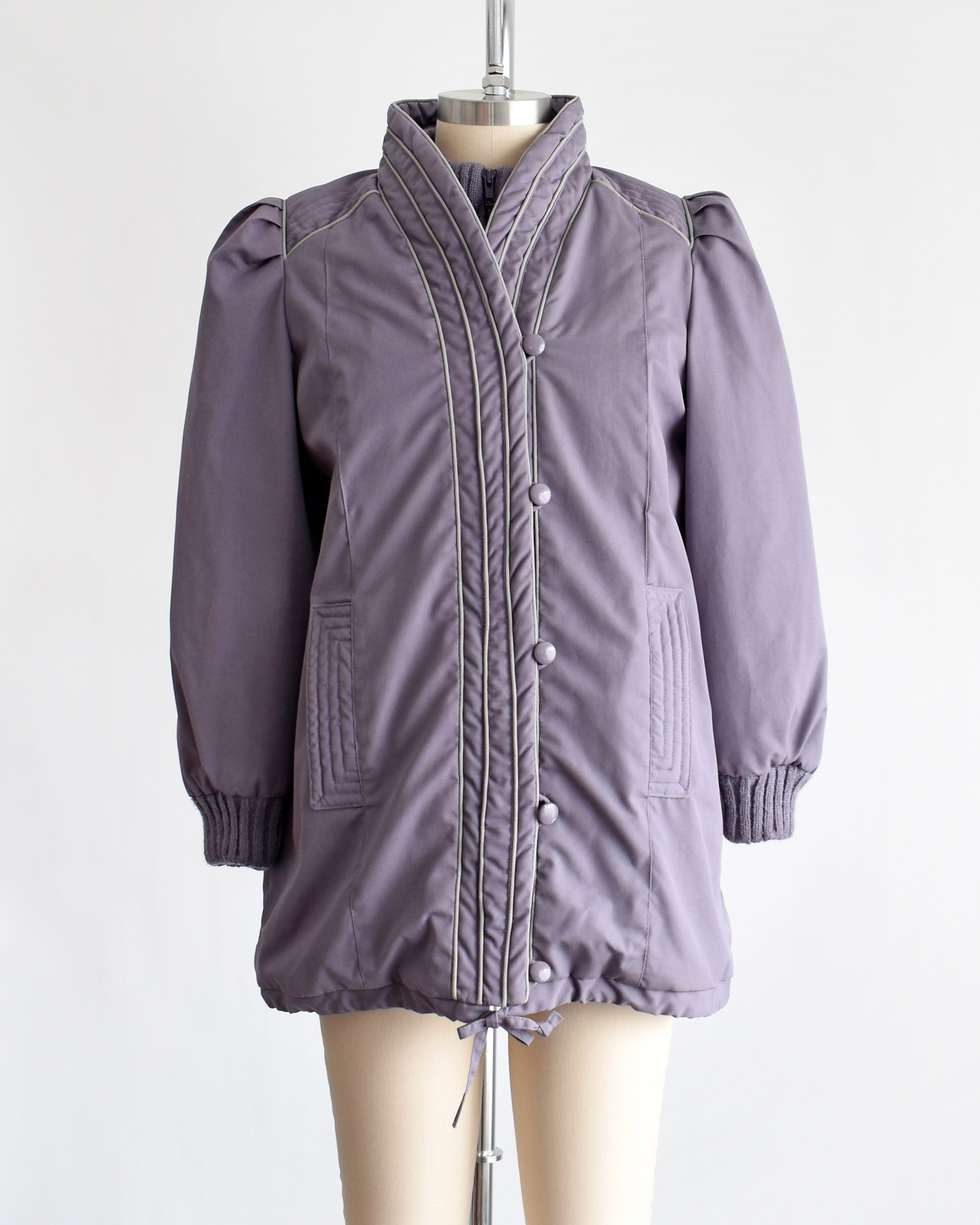 A vintage 1980s purple puffy coat with shawl style collar with gray trim