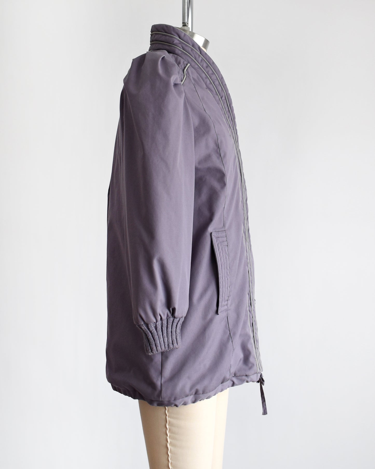 Side view of a vintage 1980s purple puffy coat with shawl style collar with gray trim