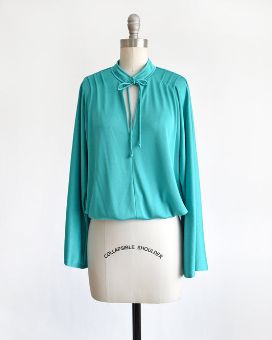 a vintage 1970s teal bell sleeve blouse