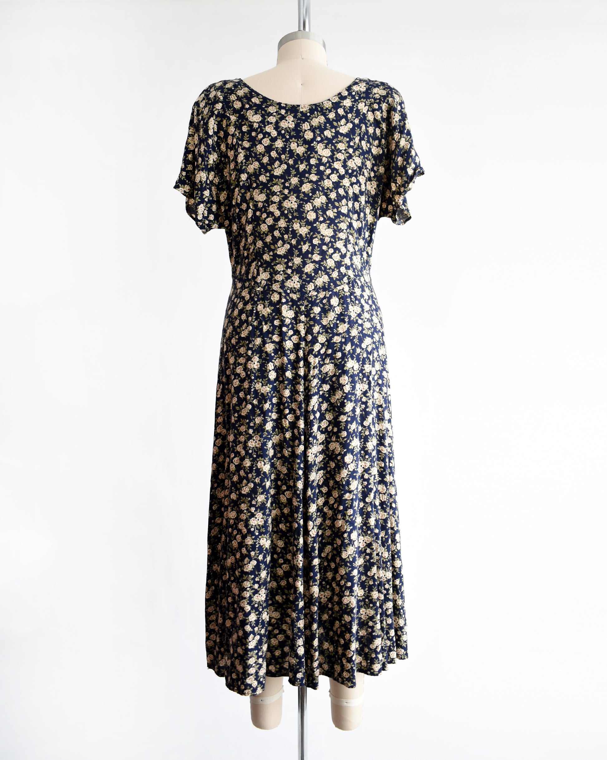 back view of a vintage 1990s floral dress on a mannequin against a white background