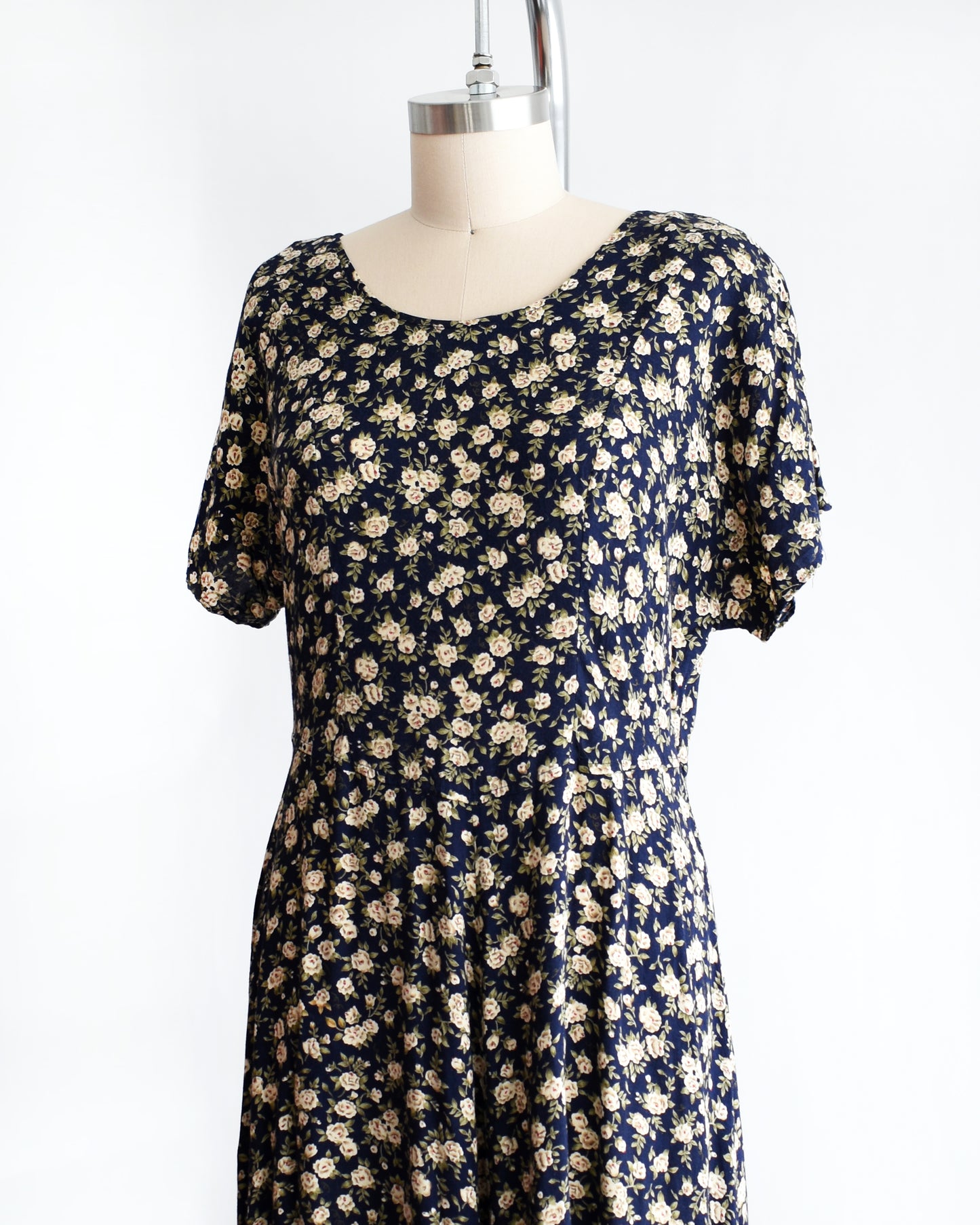 side front view of a vintage 1990s floral dress on a mannequin against a white background