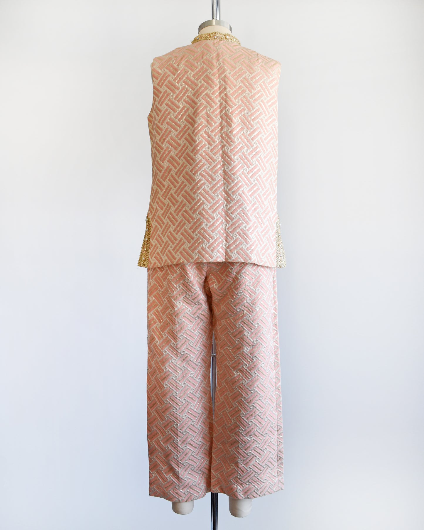 Back view of a vintage 1960s pink and gold mod pant set with a metallic gold collar with rhinestone trim. The set includes a matching top and bottoms.