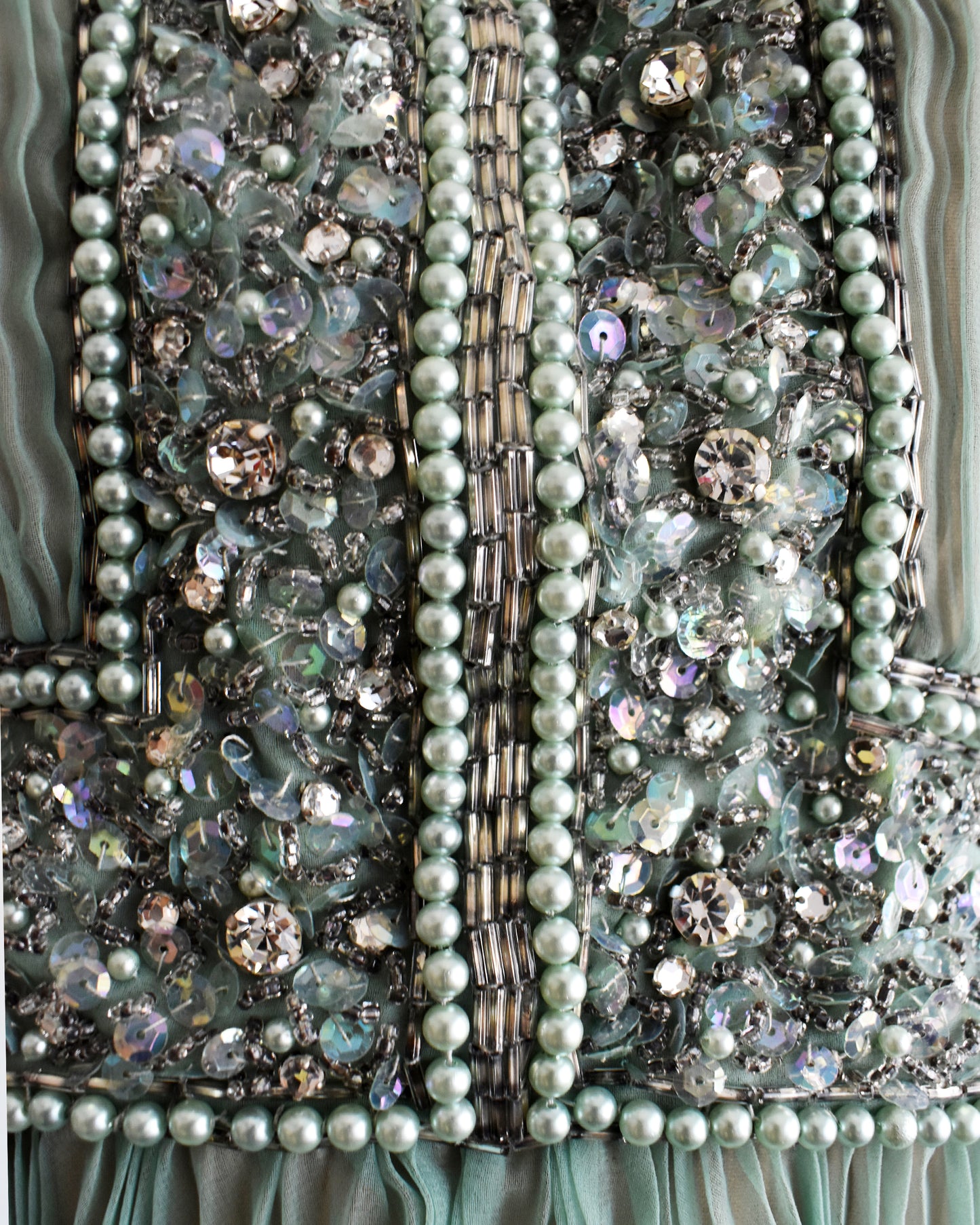 Close-up of a beaded, sequin, and rhinestone bodice on a vintage 1960s green chiffon dress