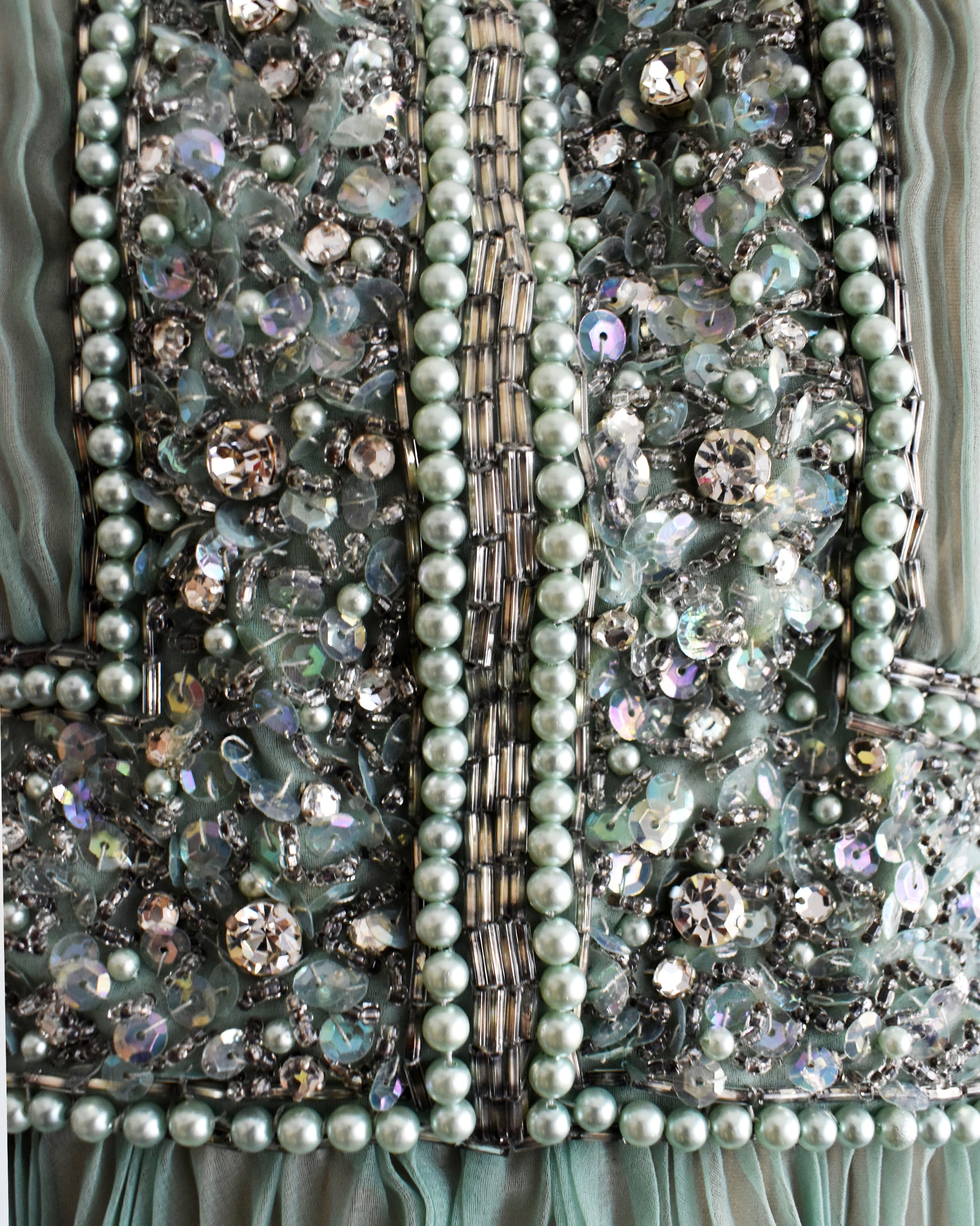 Close-up of a beaded, sequin, and rhinestone bodice on a vintage 1960s green chiffon dress