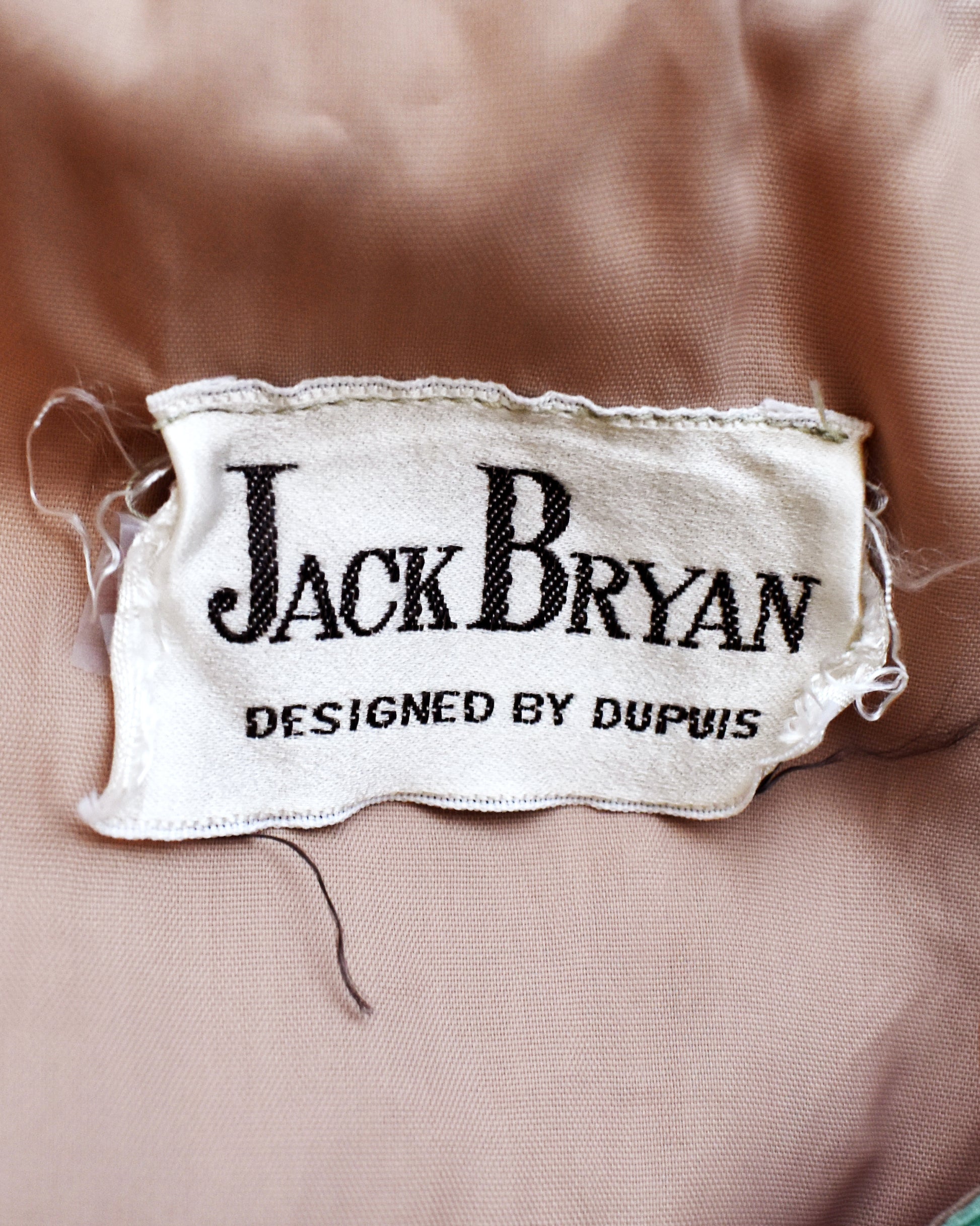 Close-up of a 'Jack Bryan' label on fabric
