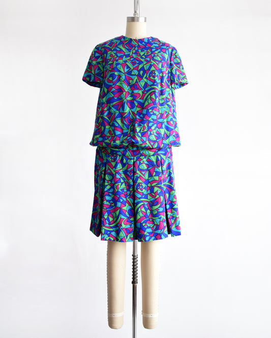 a vintage 1960s psychedelic patterned dress on a mannequin against a white background