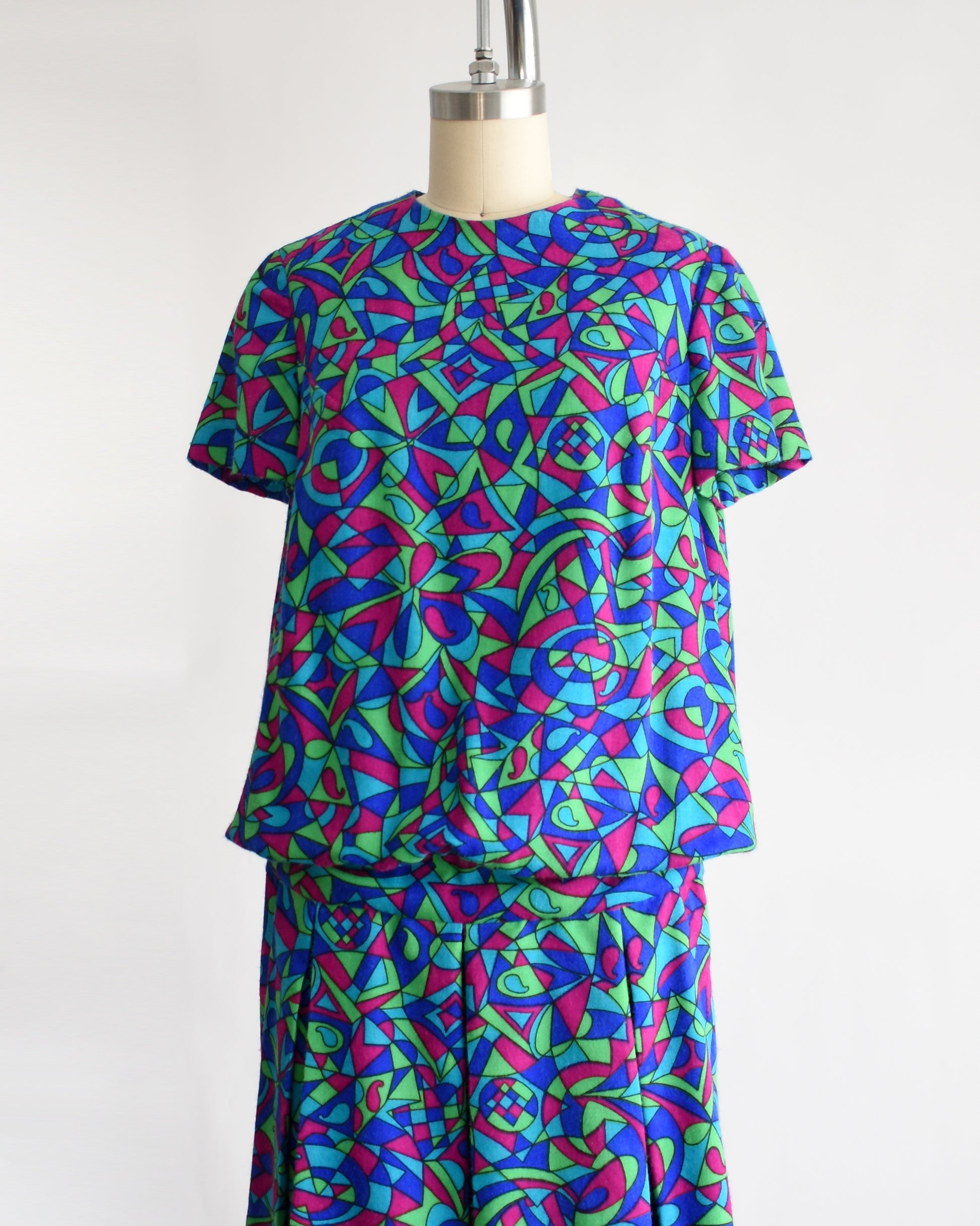 side front view of a vintage 1960s psychedelic patterned dress on a mannequin against a white background