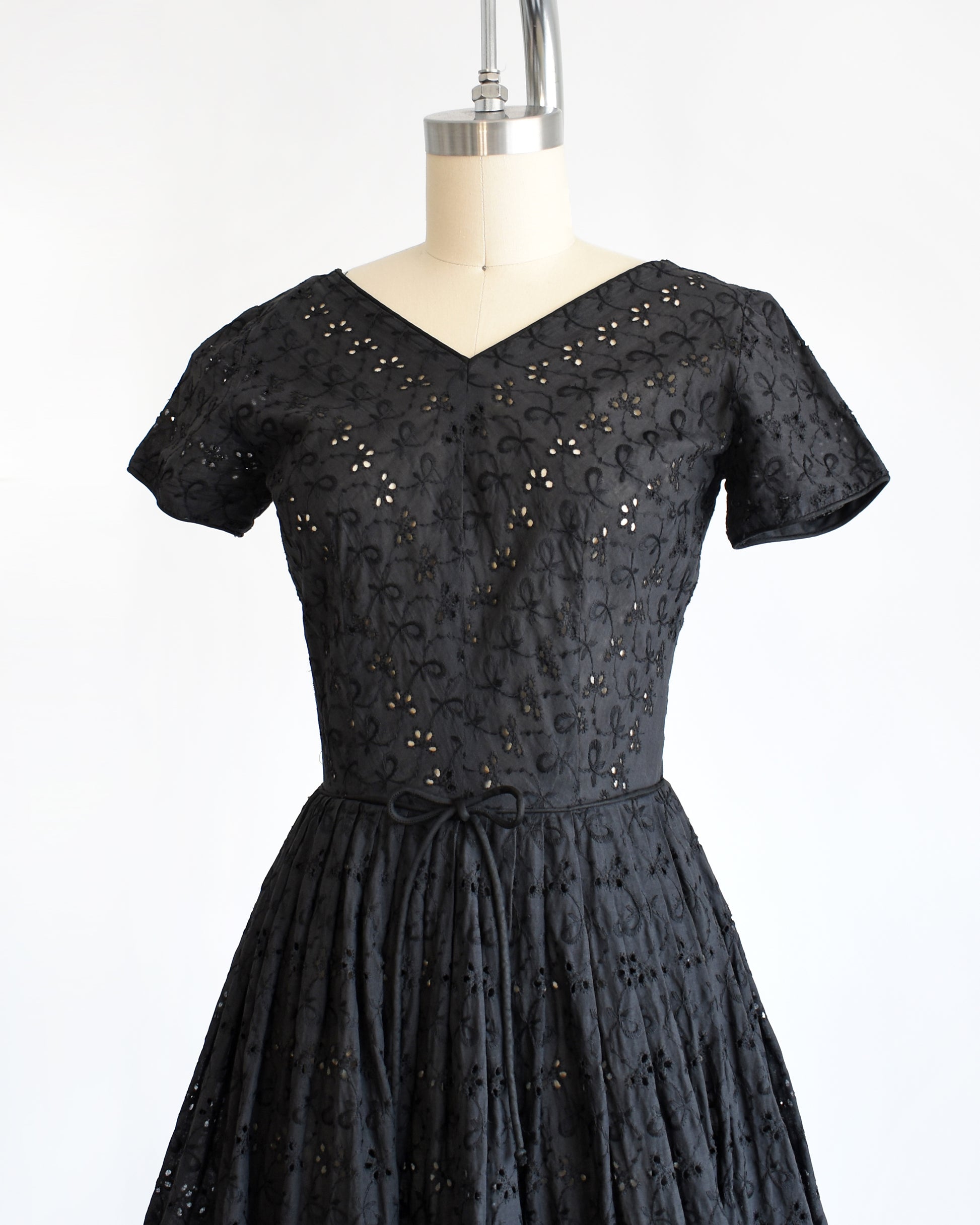 side font view of a late 1950s early 1960s vintage black eyelet dress