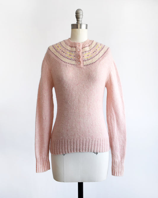 a vintage 1980s pink sweater on a mannequin against a white background