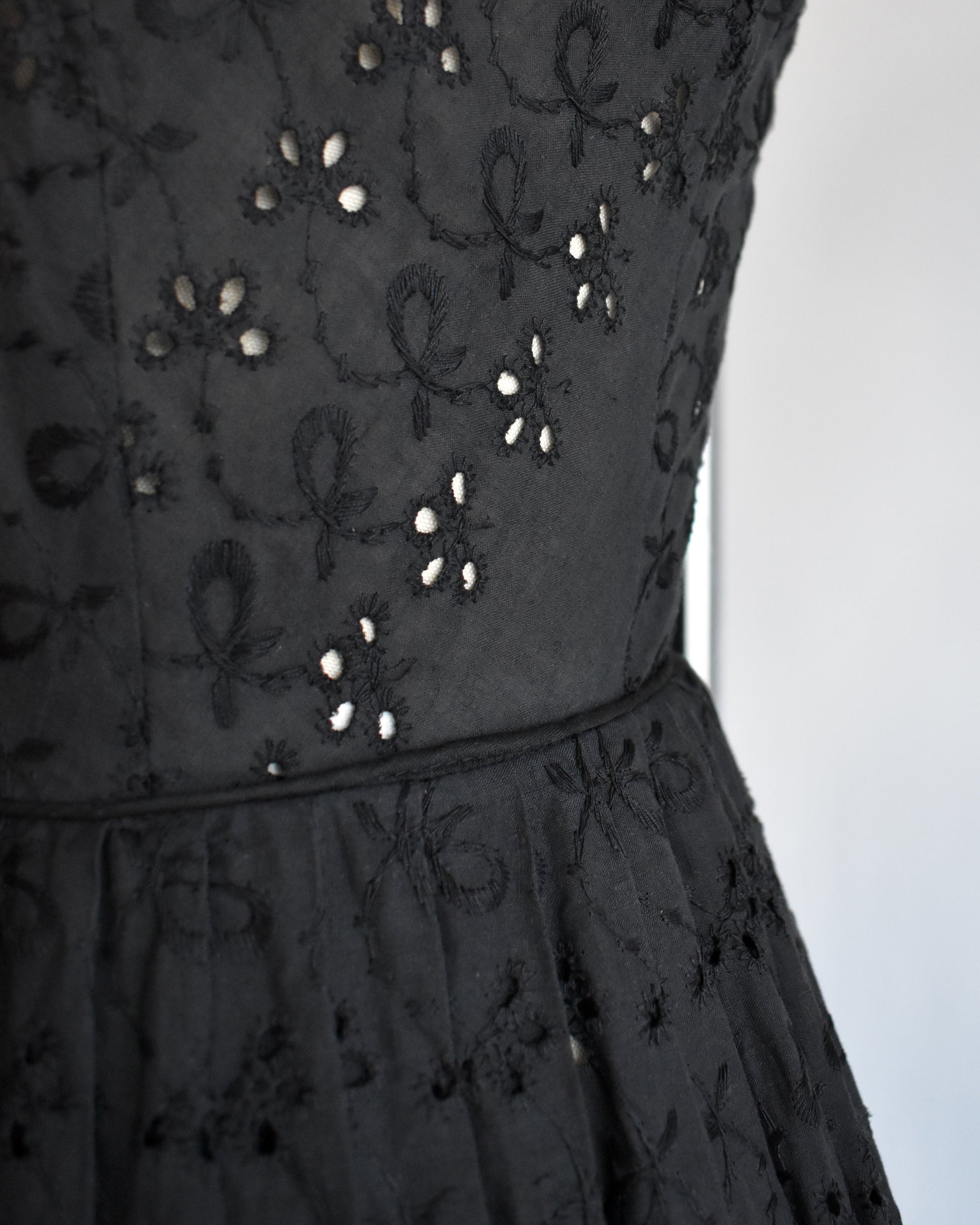 close up of the waist of a late 1950s early 1960s vintage black eyelet dress