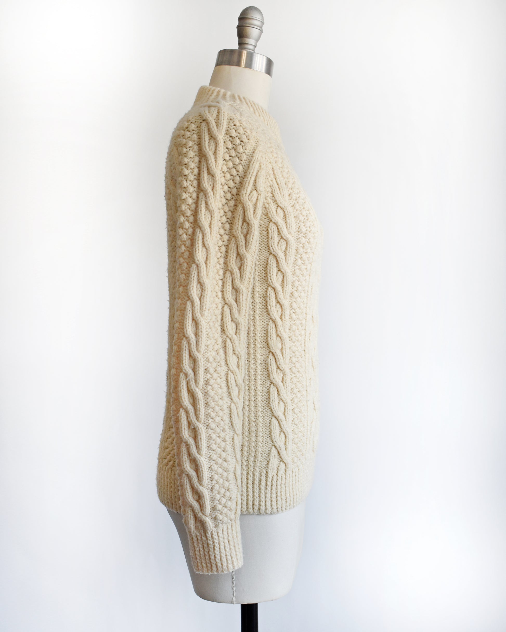 side view of a vintage 1970s cream wool cable knit sweater