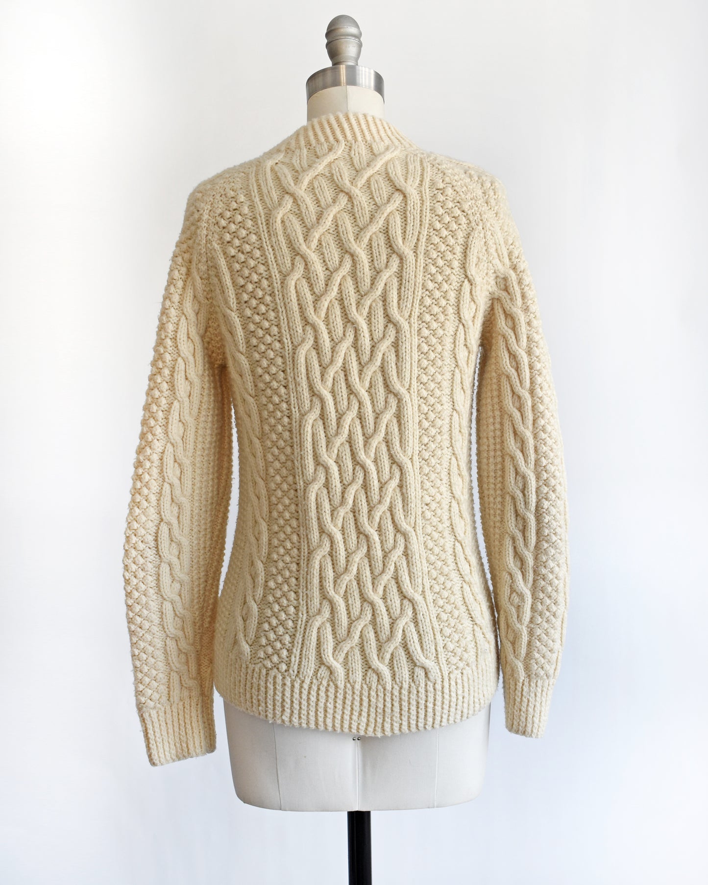 back view of a vintage 1970s cream wool cable knit sweater