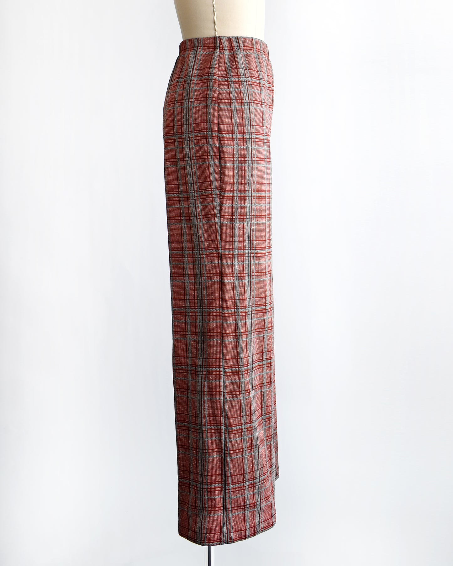 side view of vintage 1970s red plaid pants on a mannequin against a white background