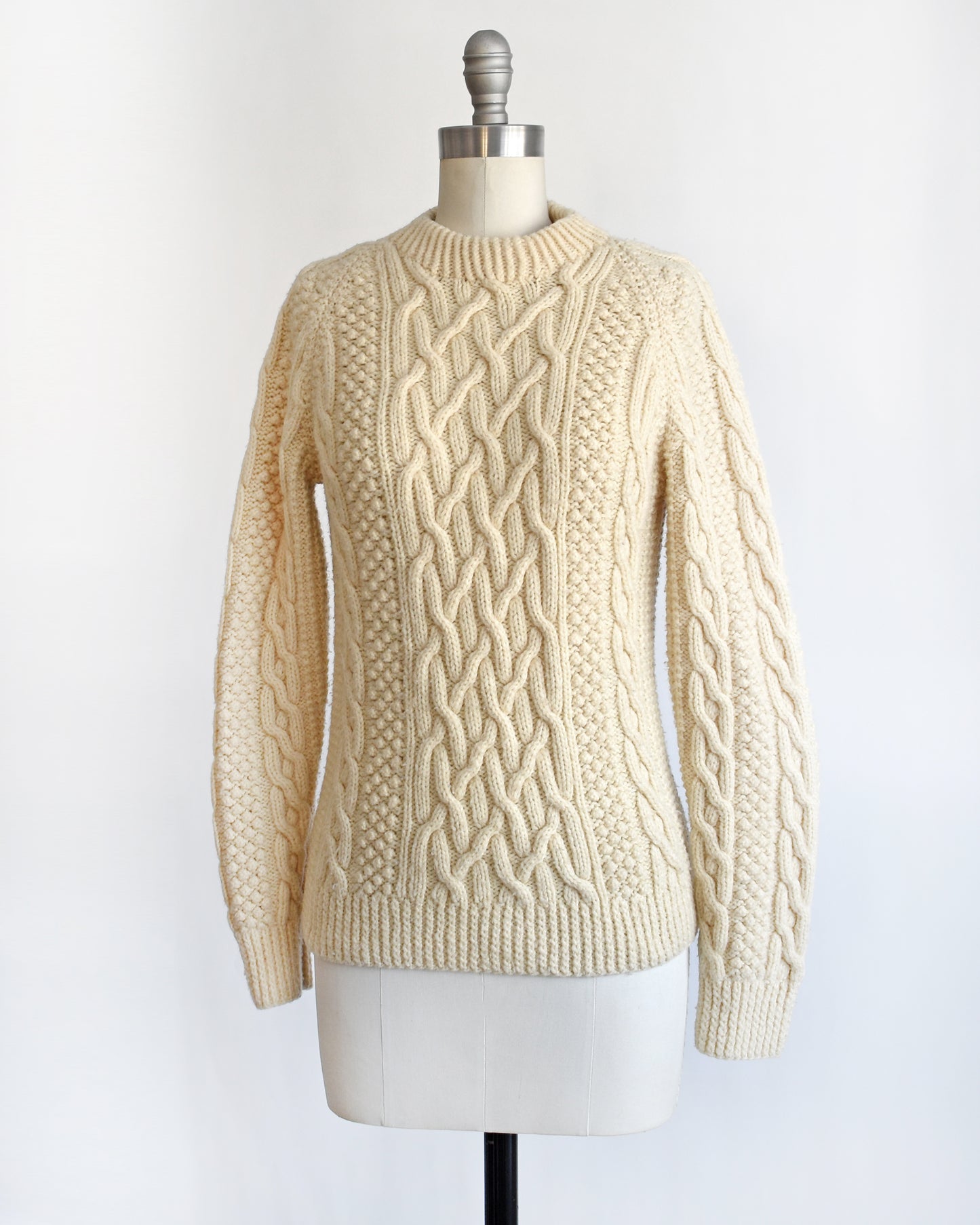 side front view of a vintage 1970s cream wool cable knit sweater