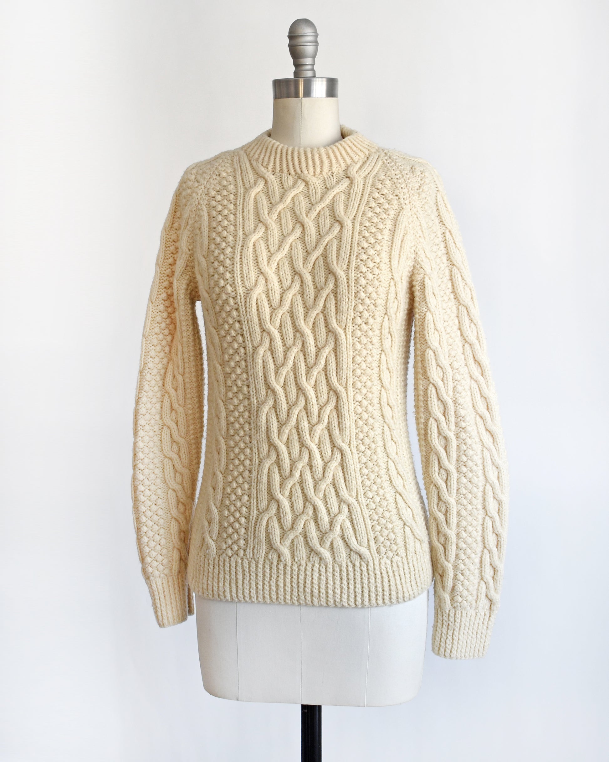 side front view of a vintage 1970s cream wool cable knit sweater