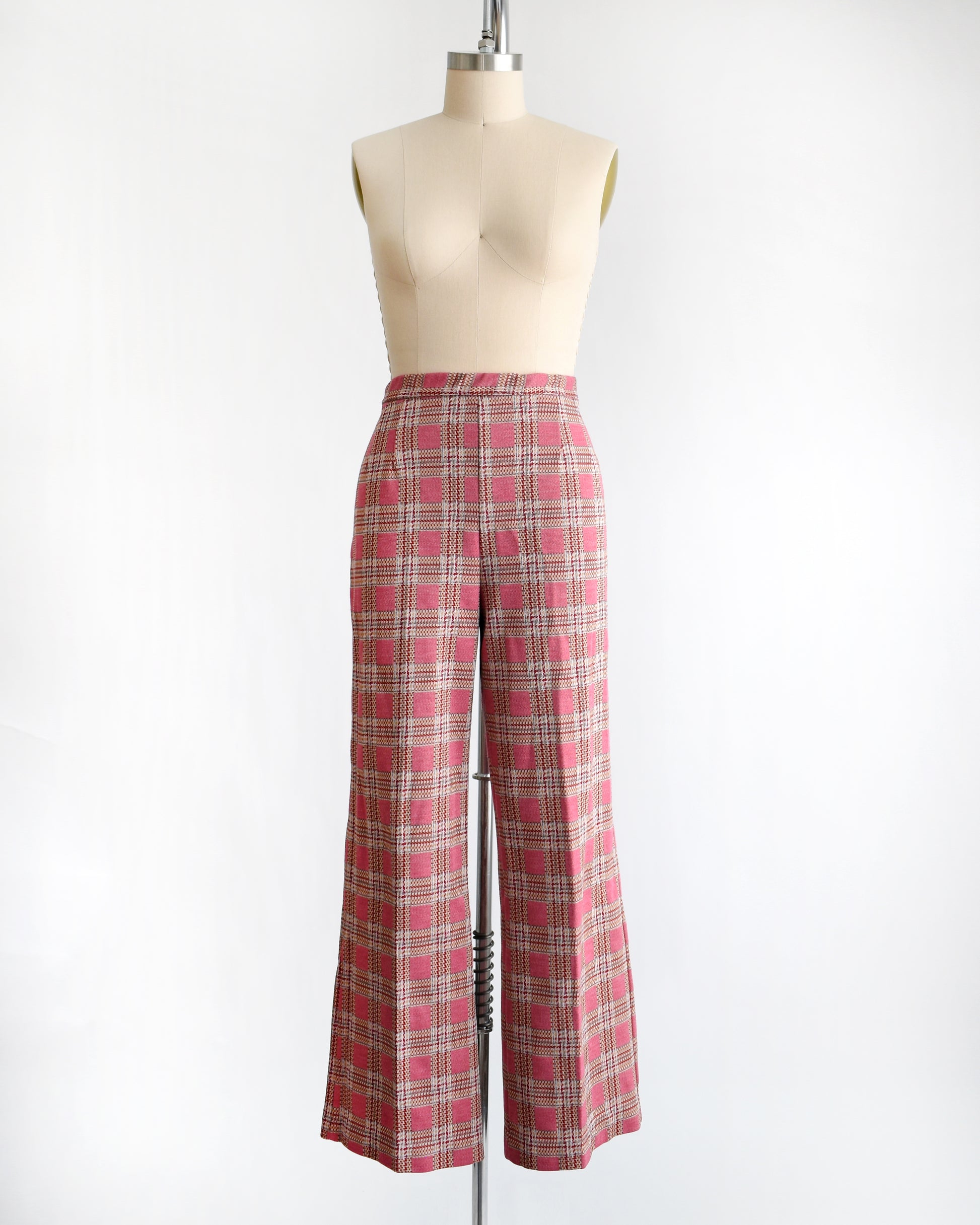 vintage 1970s pink plaid pants on a mannequin against a white background