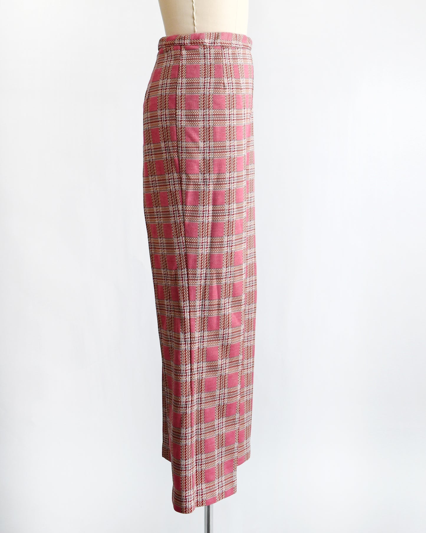 side view of vintage 1970s pink plaid pants on a mannequin against a white background