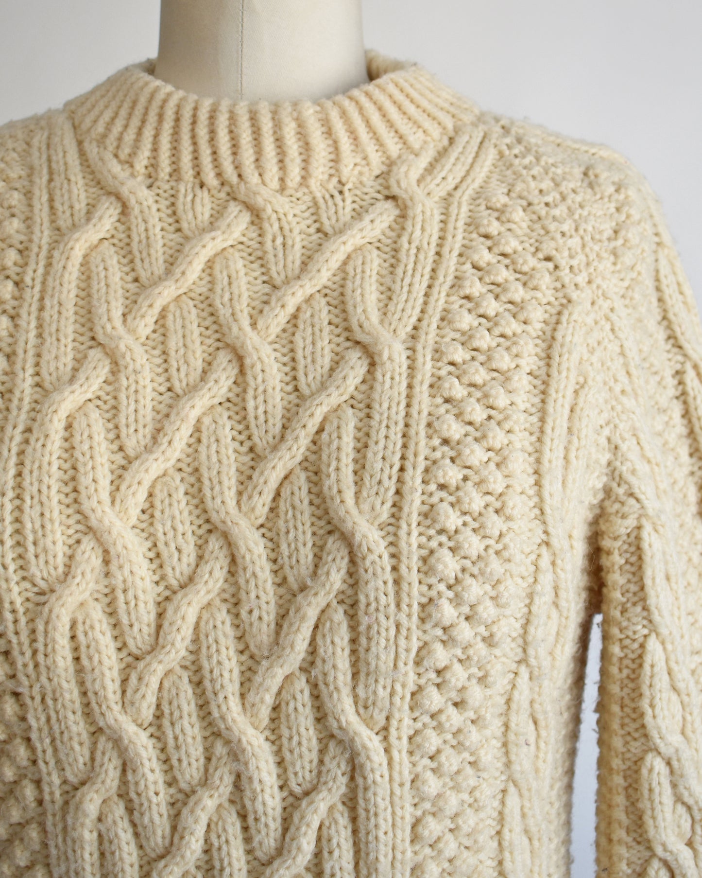 close up of a vintage 1970s cream wool cable knit sweater