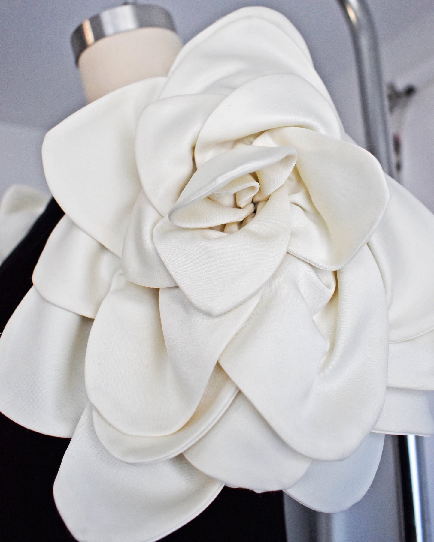 close up of the floral sleeve on a vintage 1980s Victor Costa black dress with white floral sleeves on a mannequin against a white background