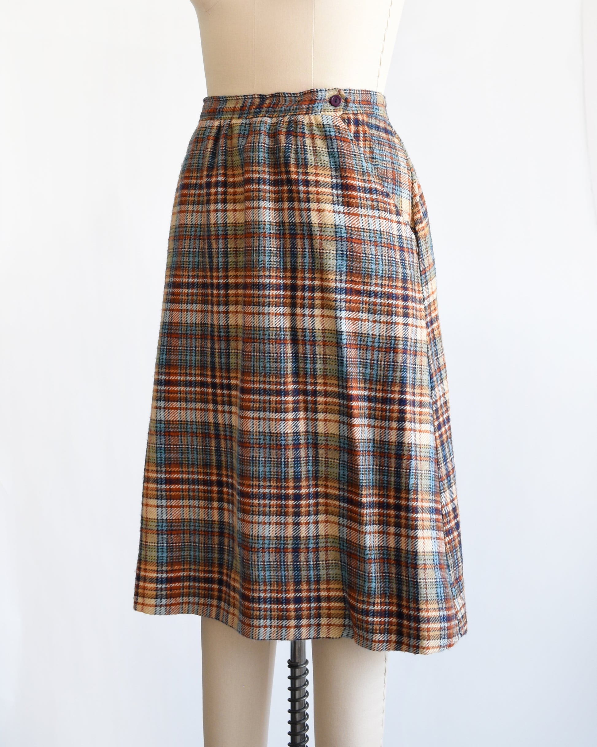 side front view of a vintage 1970s brown and blue plaid skirt on a dress form against a white background