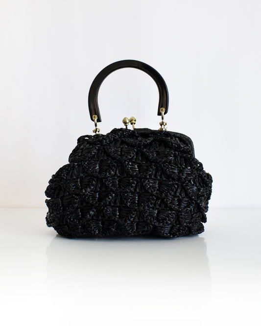 a vintage black woven raffia handbag with a handle on a white background