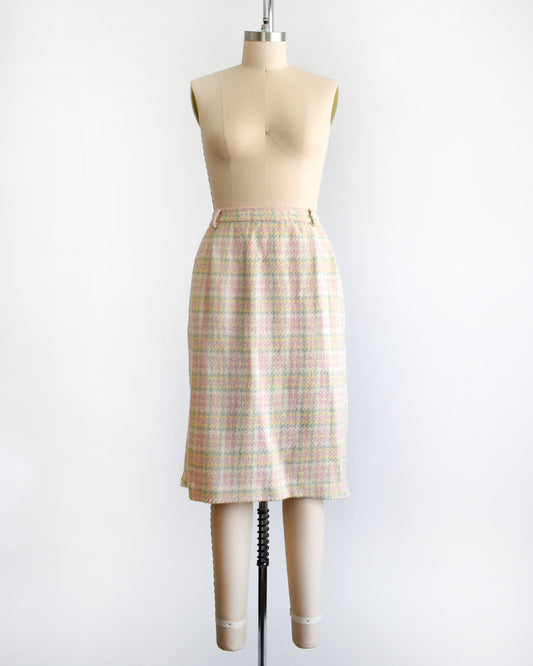 a vintage pink plaid skirt on a mannequin against a white background