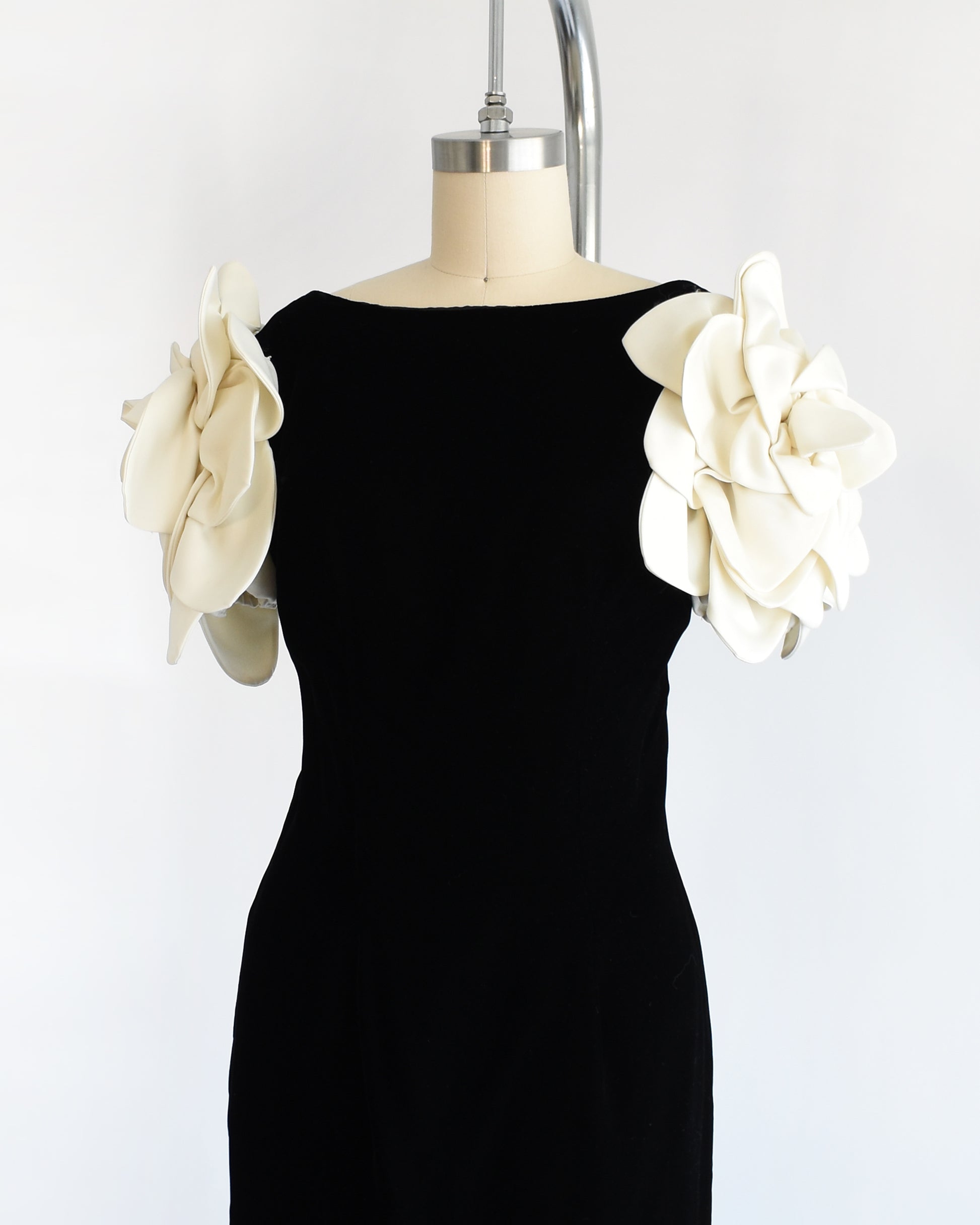 side front view of a vintage 1980s Victor Costa black dress with white floral sleeves on a mannequin against a white background