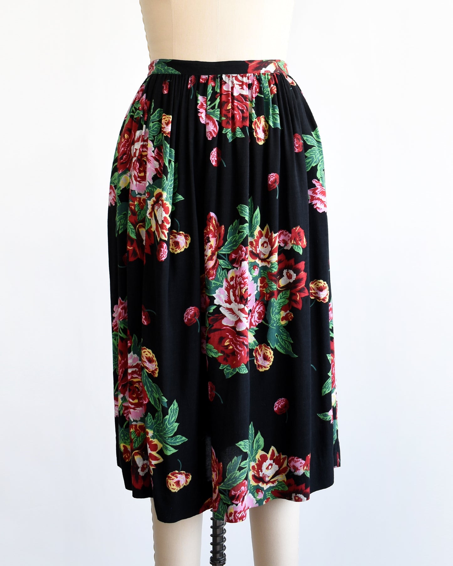 a vintage 1990s black floral skirt on a mannequin against a white background