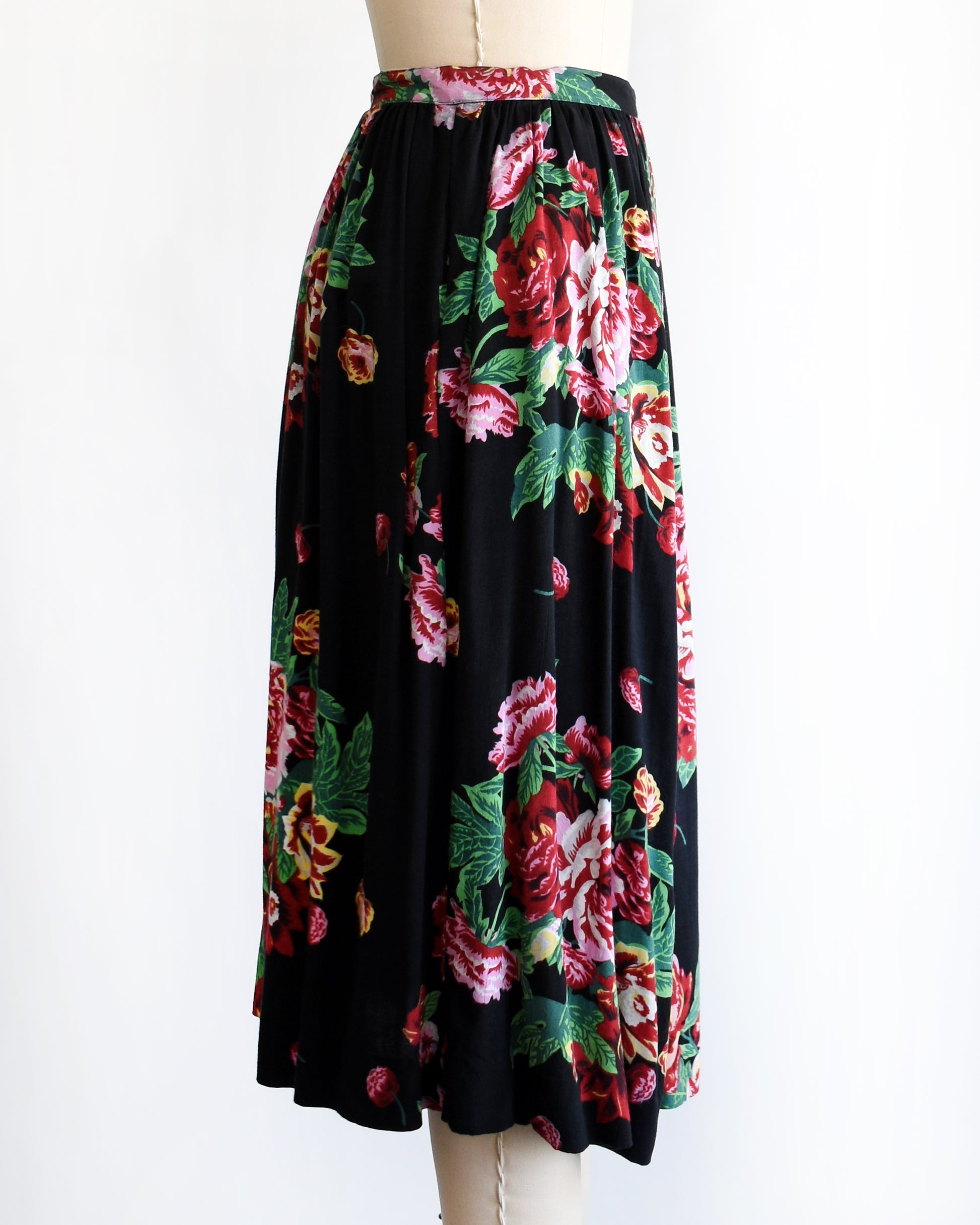 side view of a vintage 1990s black floral skirt on a mannequin against a white background