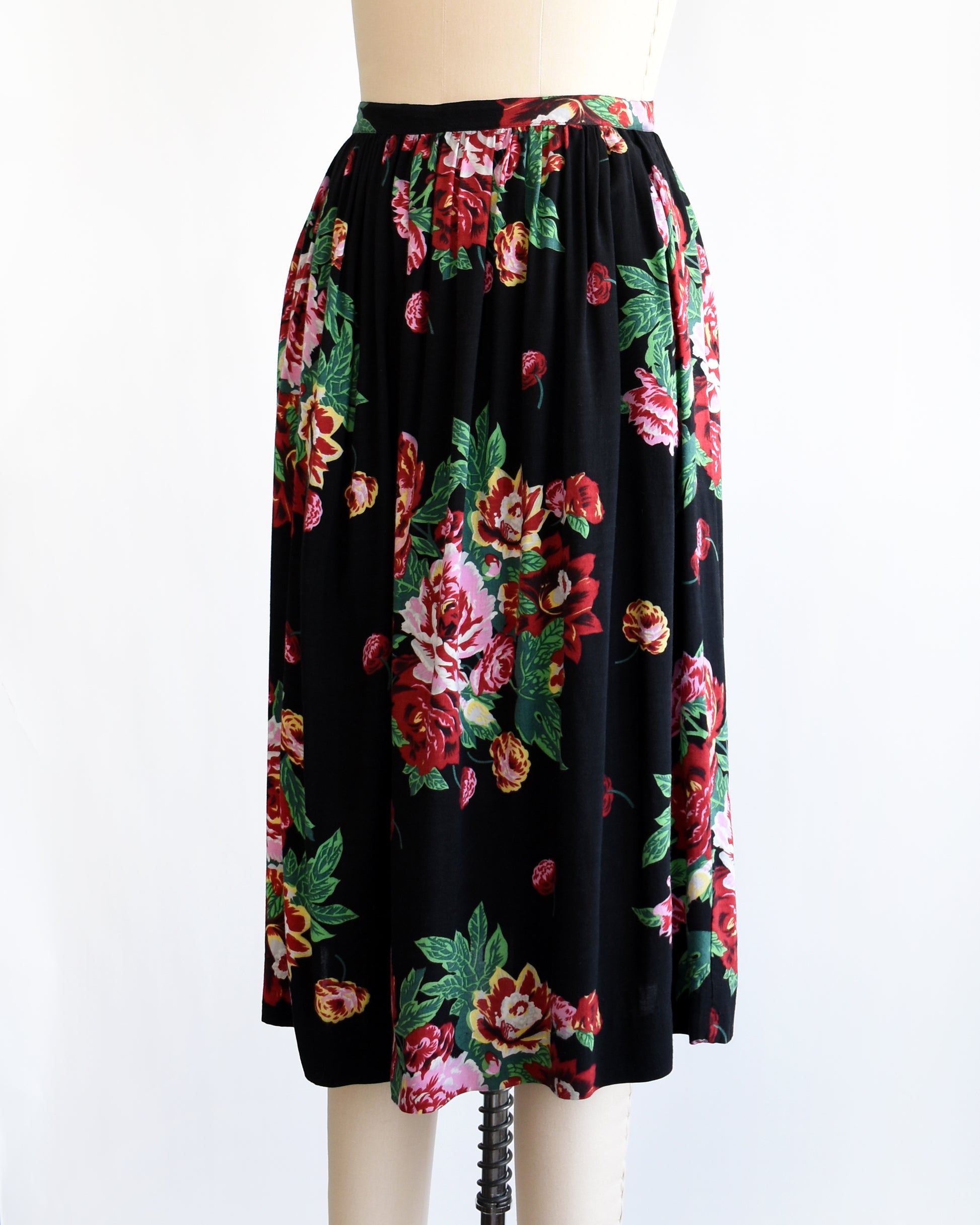 side front view of a vintage 1990s black floral skirt on a mannequin against a white background