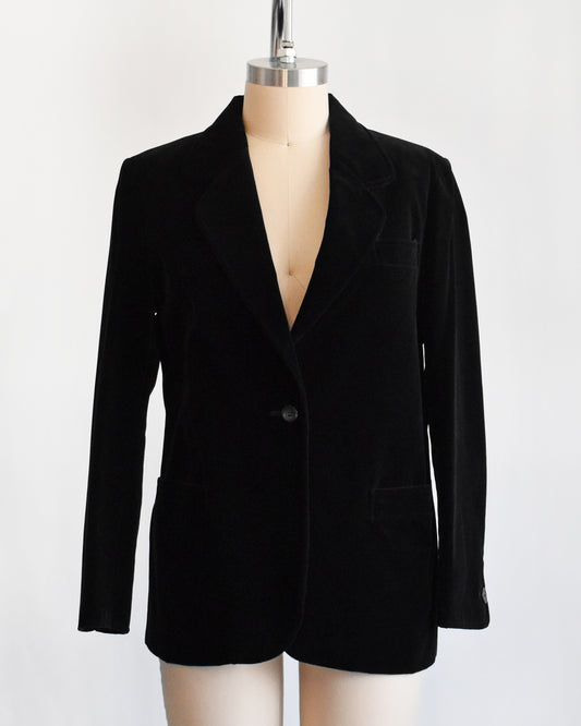 a vintage black blazer on a mannequin against a white background